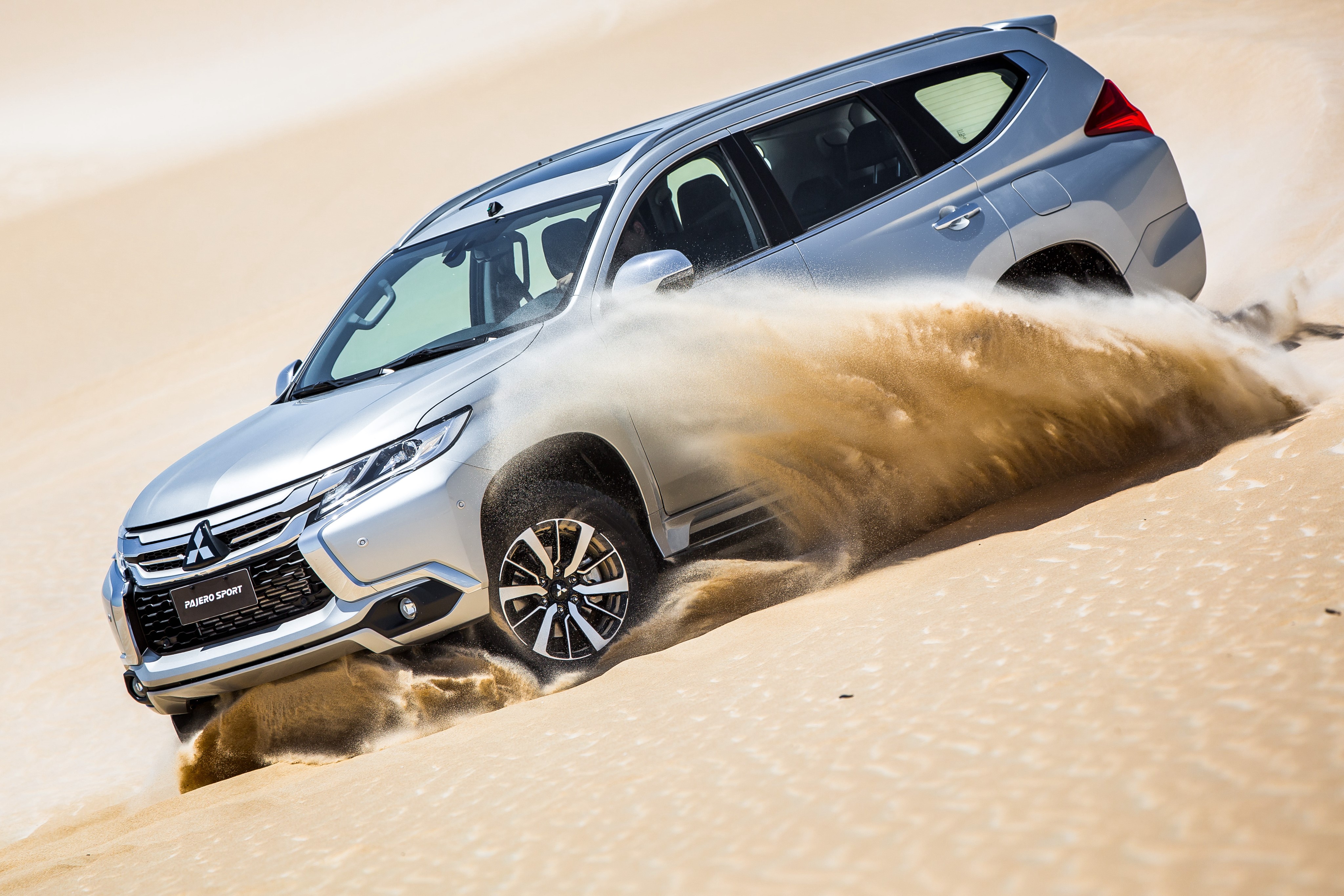 Silver Mitsubishi Pajero Sport driving on sand HD Wallpaper