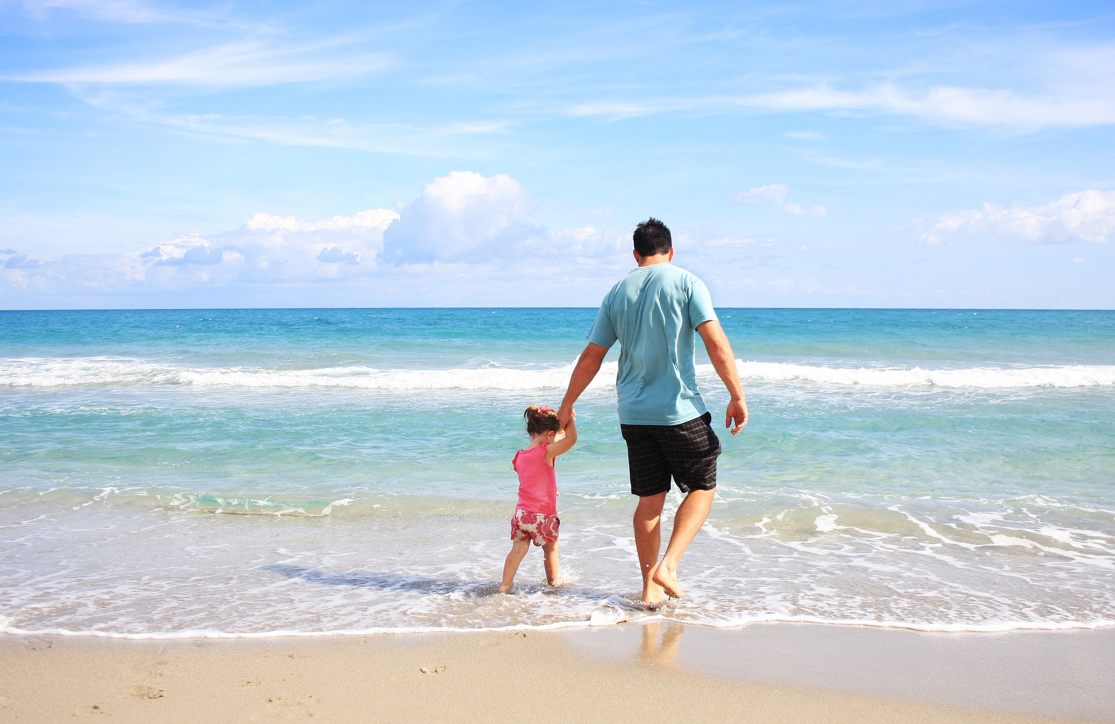 Father and daughter walking on a beach HD Wallpaper