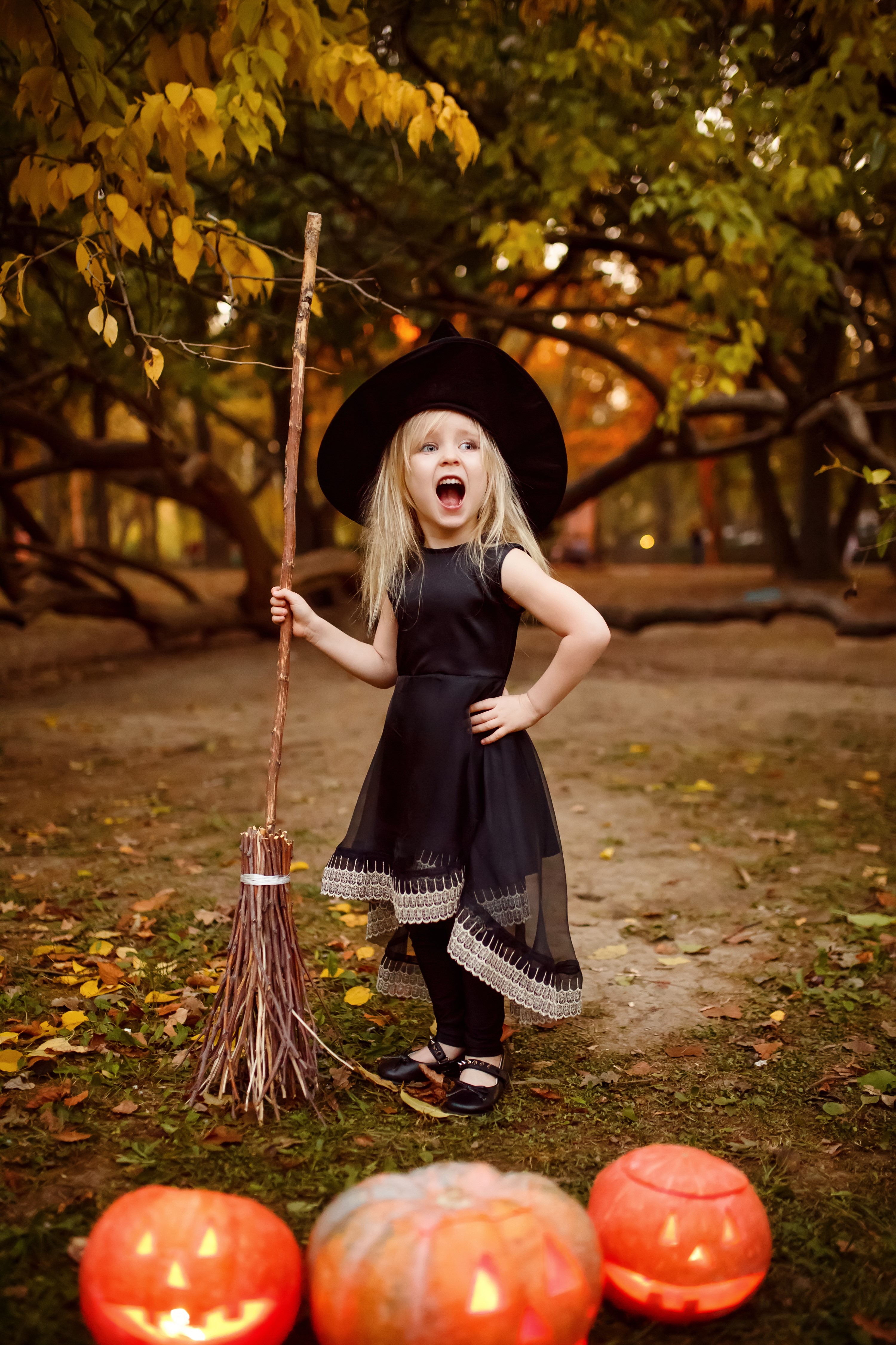 Little girl in witch costume with broom and pumpkins HD Phone Wallpaper