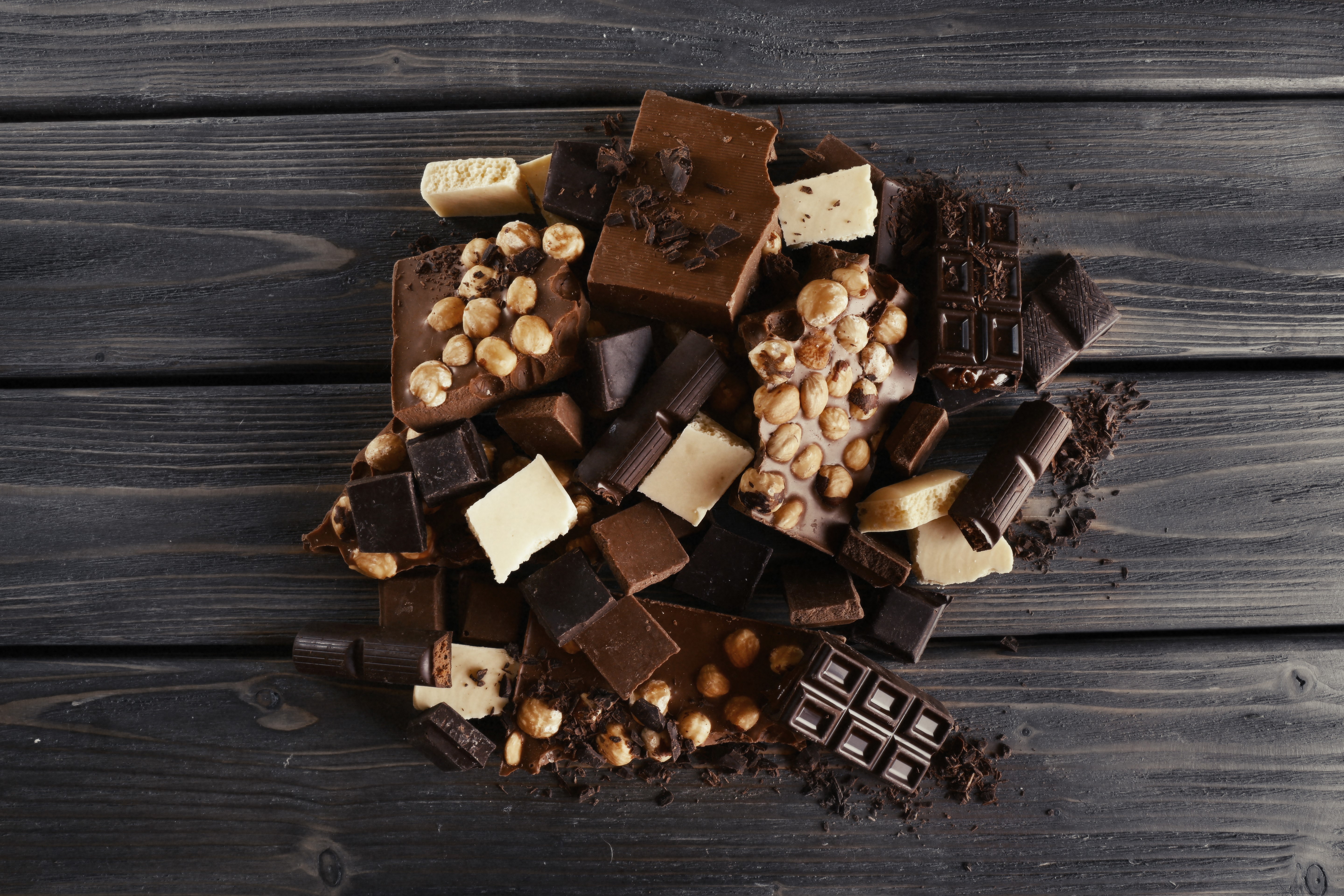 Chocolate pieces with nuts on wooden planks HD Wallpaper