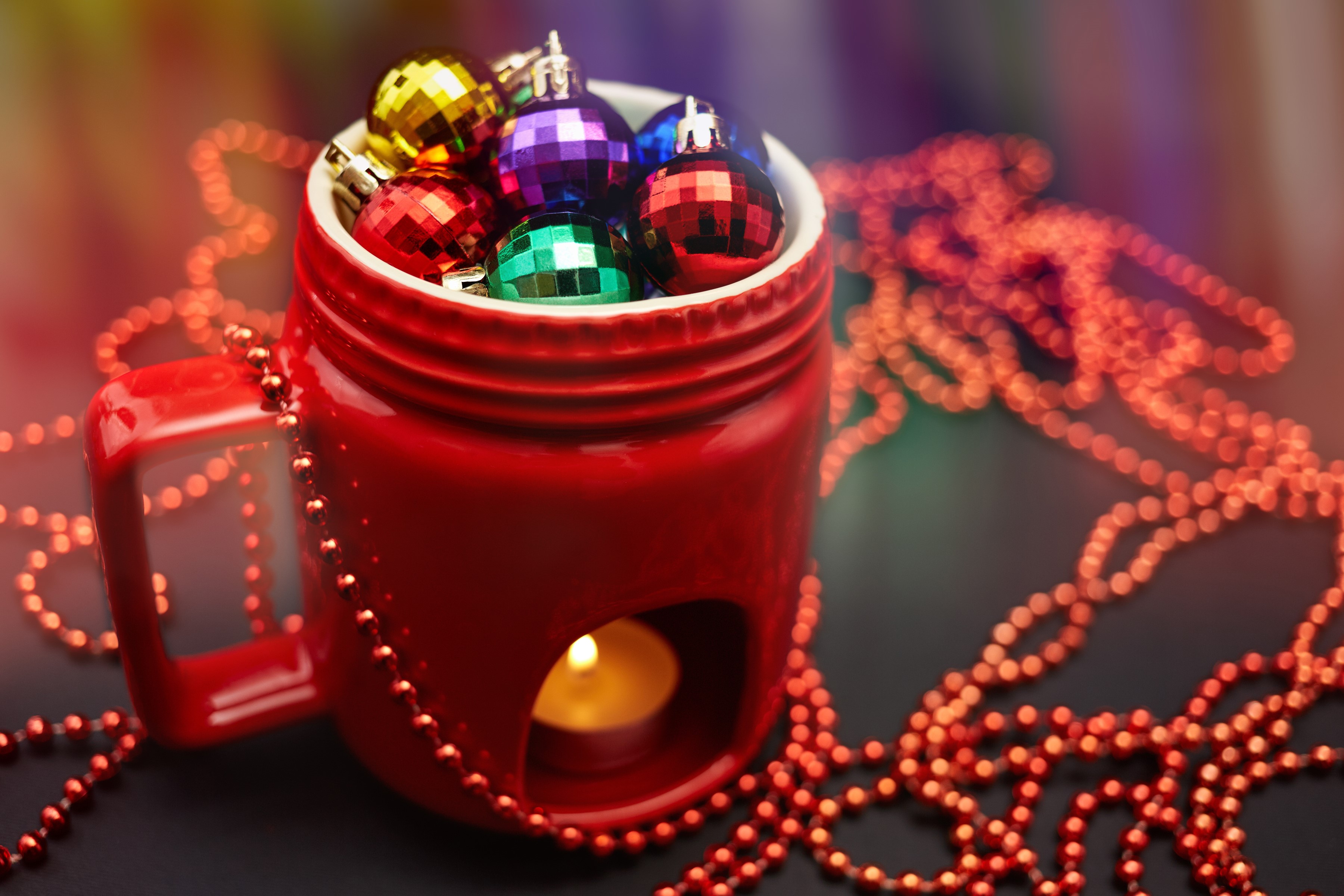 Christmas ornaments in a red mug with a candle HD Wallpaper
