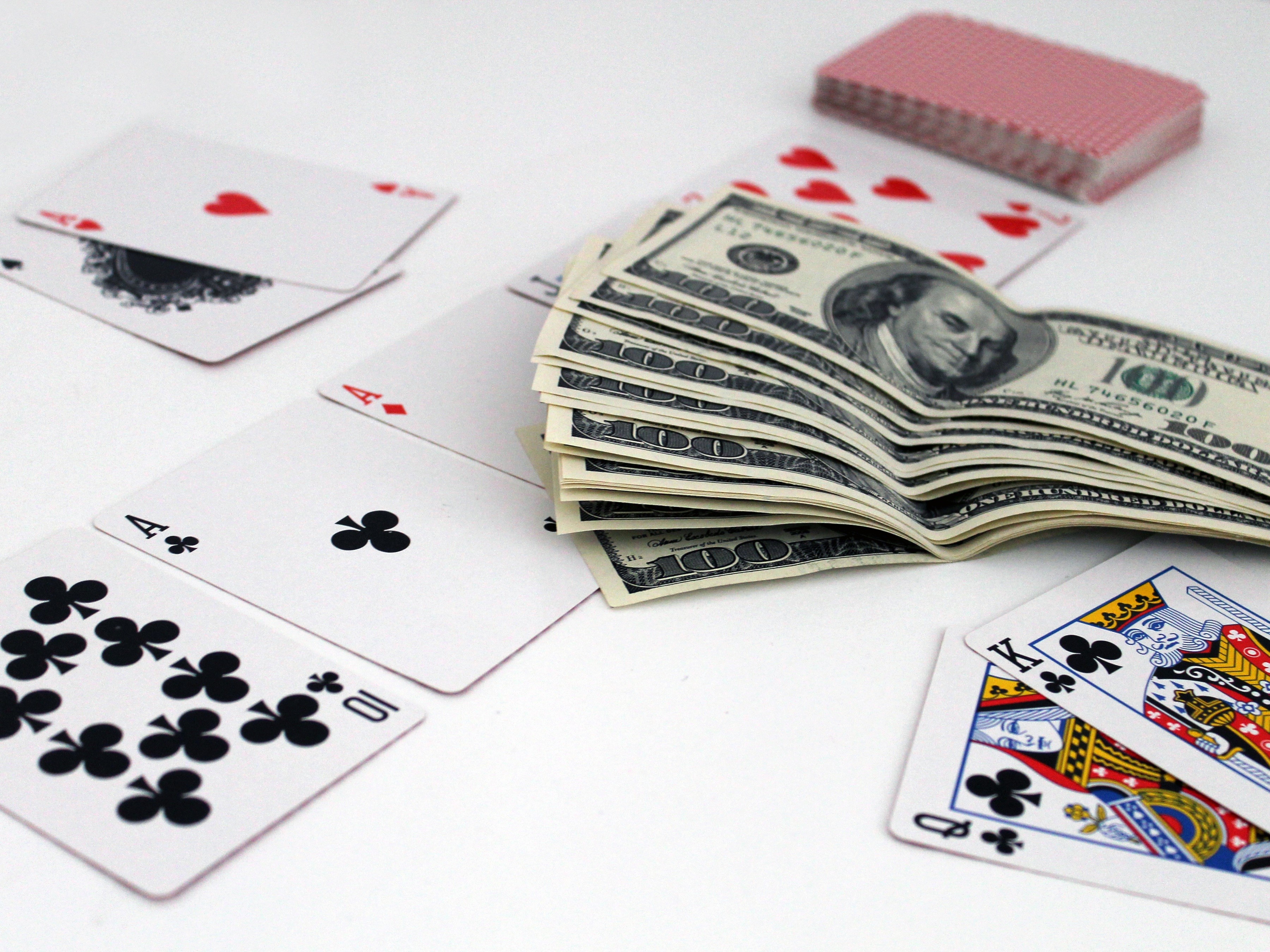 Playing Cards and US Dollar Bills on White Surface HD Wallpaper