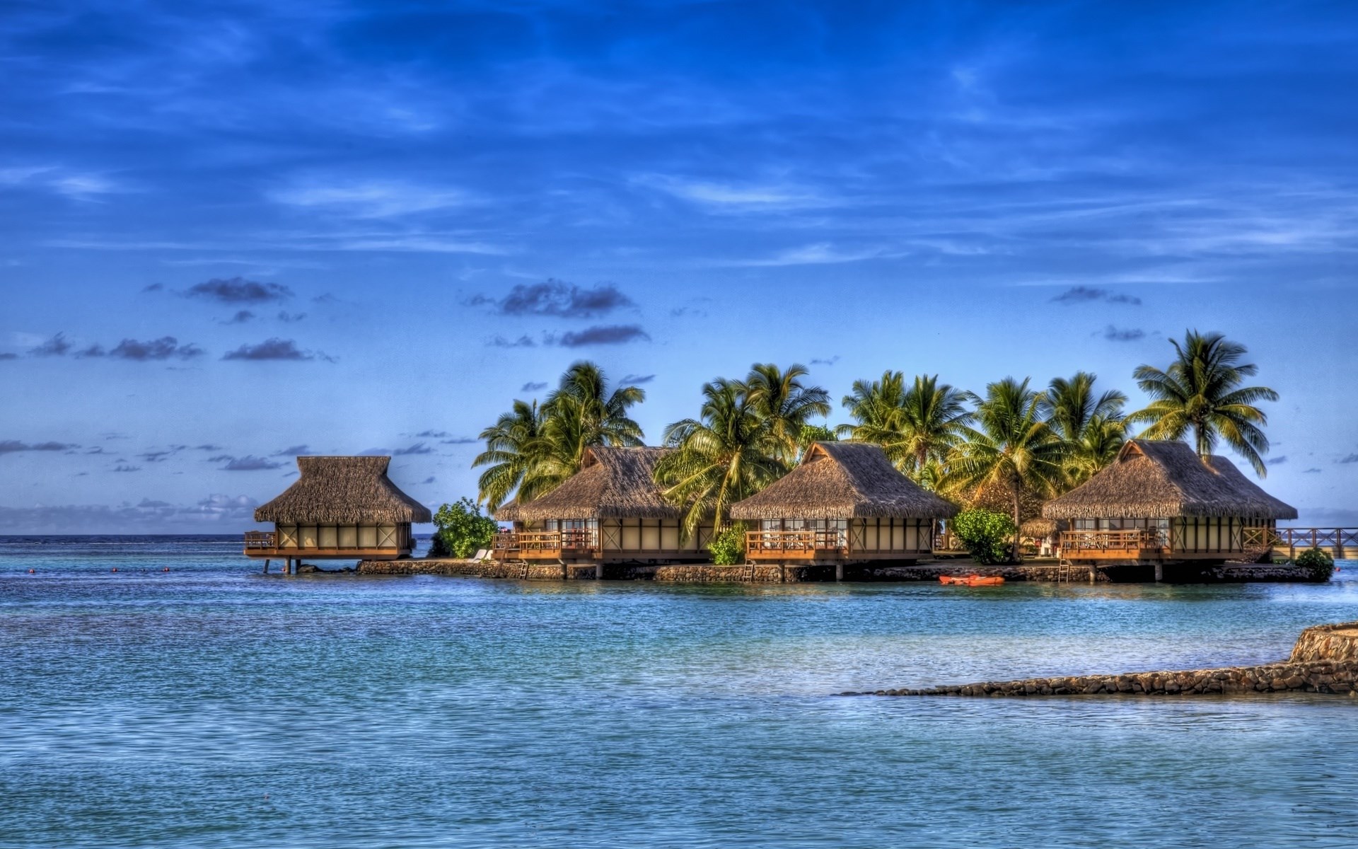 Overwater bungalows with thatched roofs and palm trees HD Wallpaper