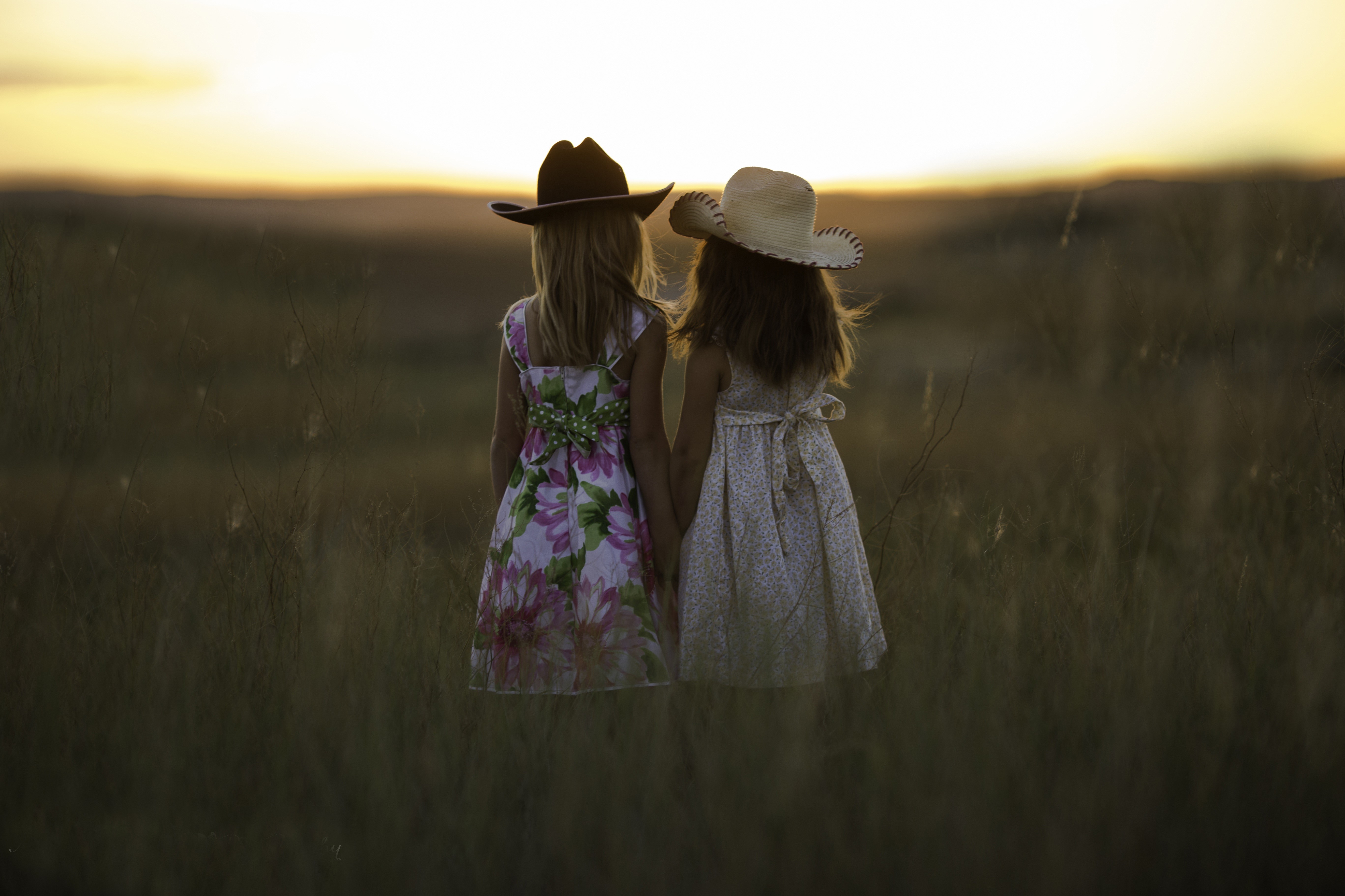 Two little girls in hats at sunset HD Wallpaper