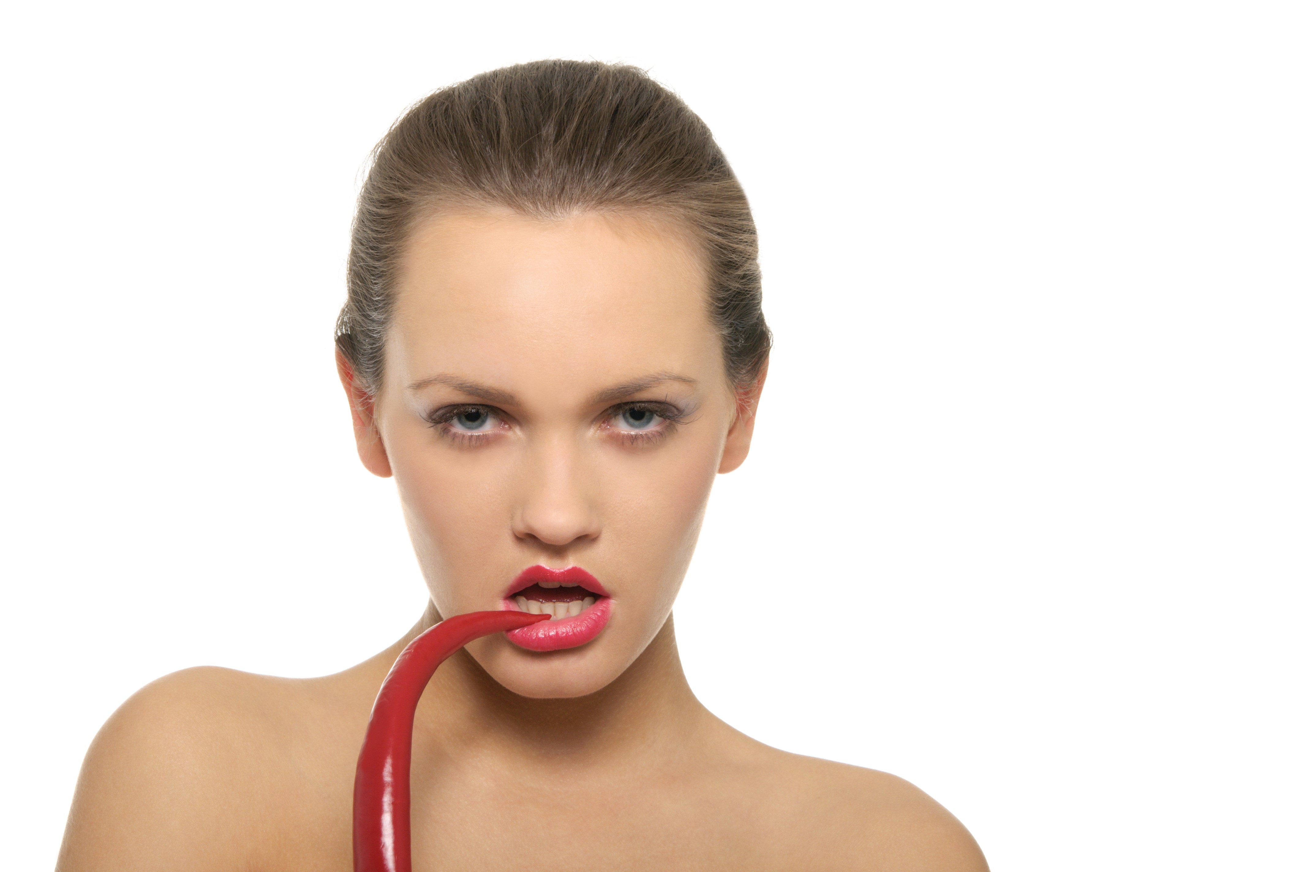 Woman biting a red chili pepper HD Wallpaper