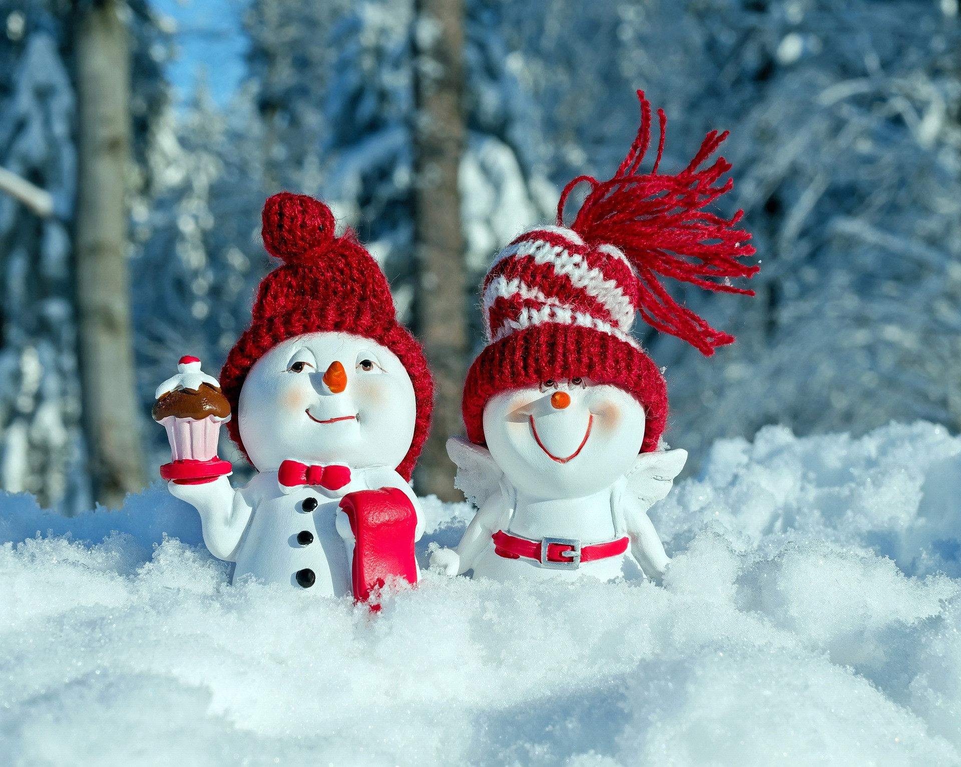 Two snowmen in winter hats with a cupcake HD Wallpaper