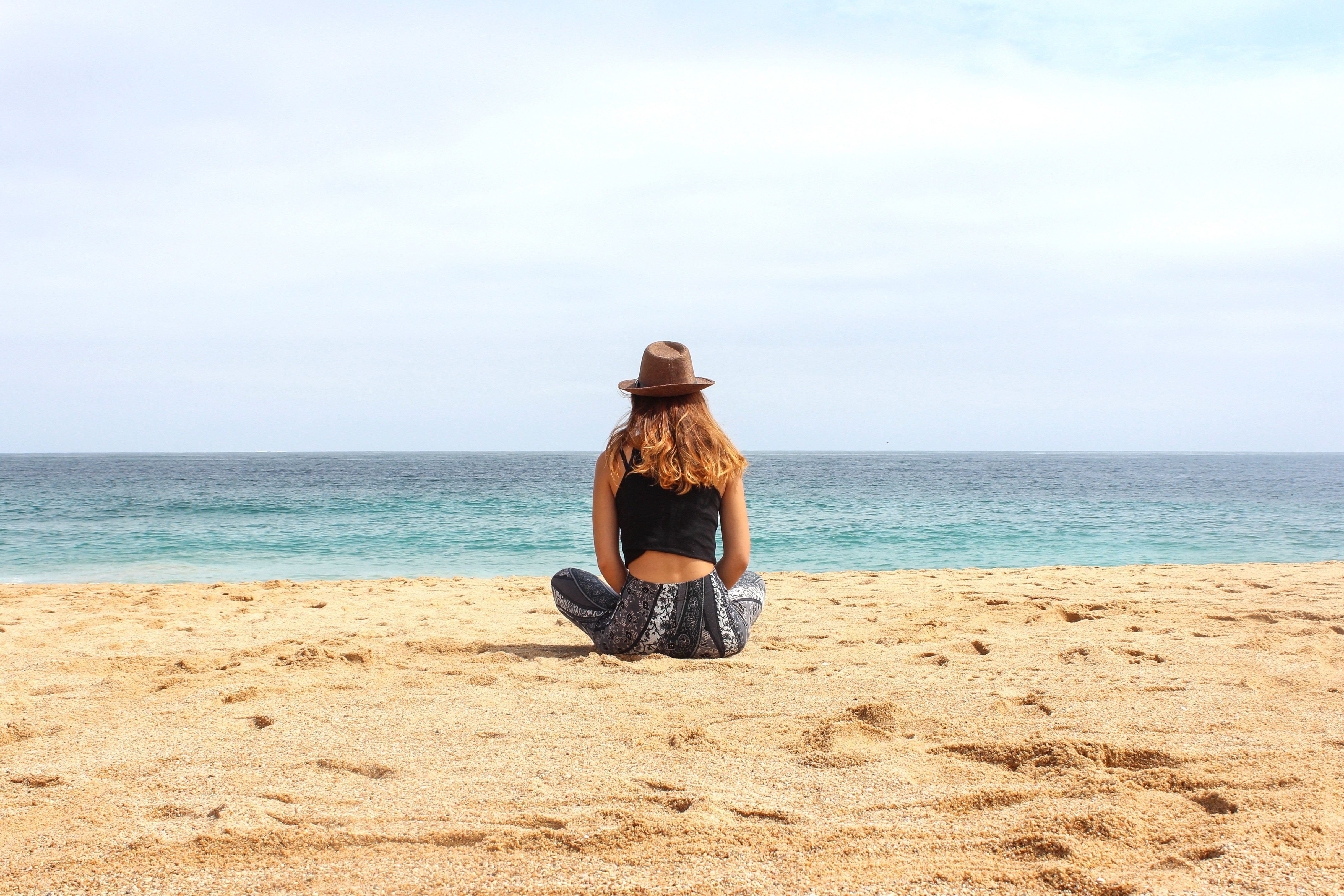 Woman in Hat Sitting on Beach HD Wallpaper
