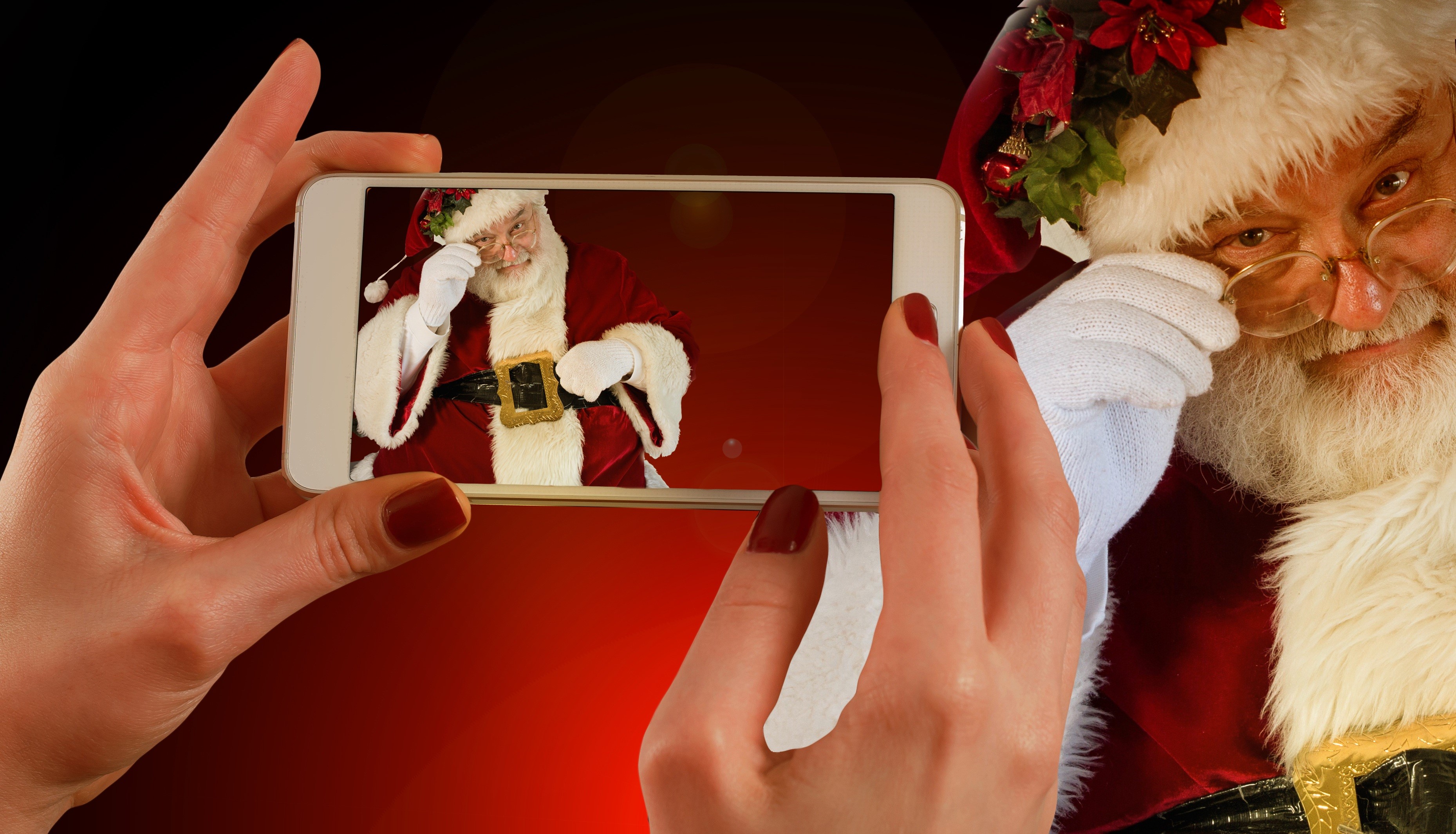 Santa Claus on a smartphone screen held by hands HD Wallpaper