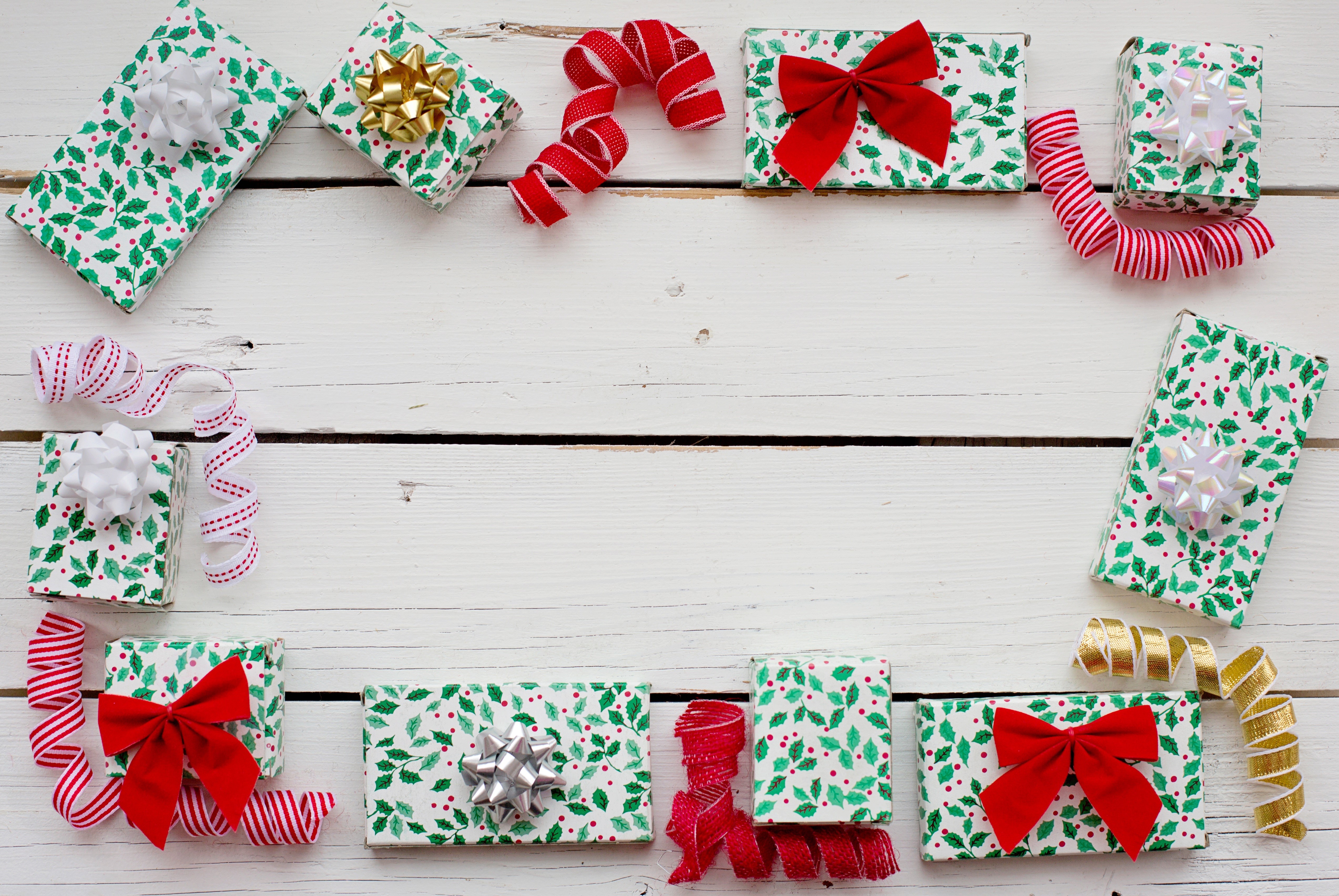 Christmas Gifts with Holly Pattern and Ribbons on Wood HD Wallpaper