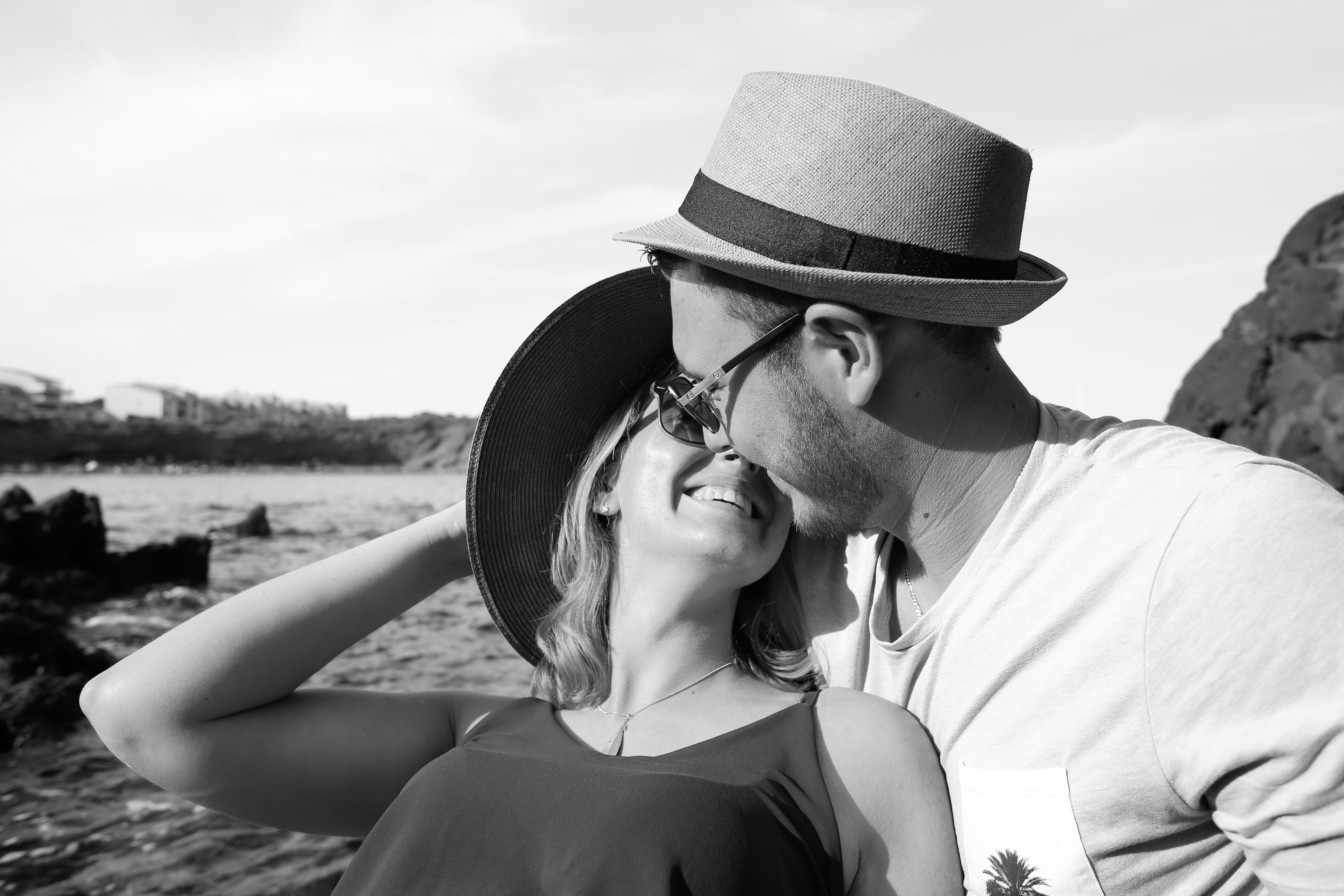 Couple in love wearing hats and glasses by the sea HD Wallpaper