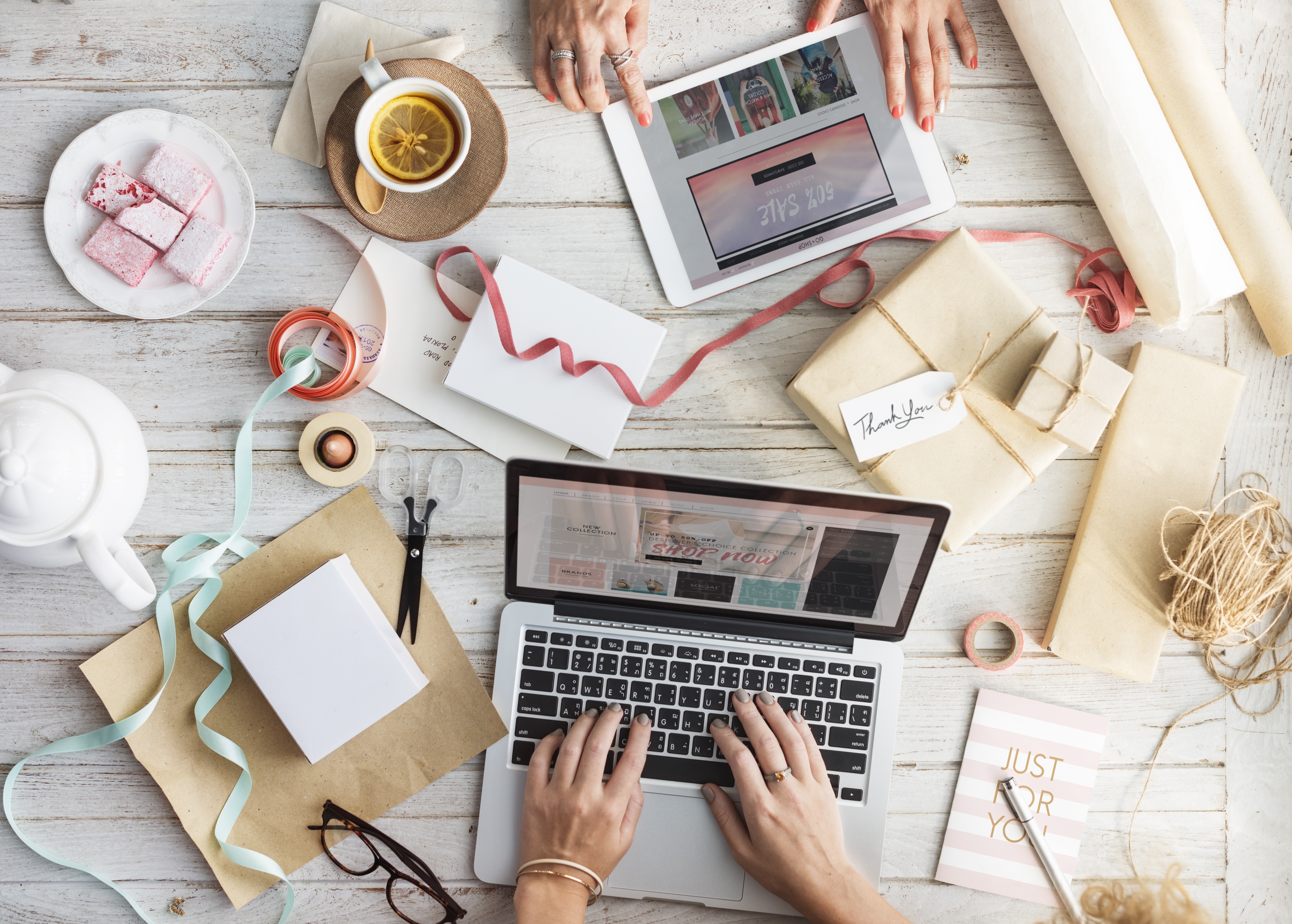 Hands typing on laptop with gifts and tea HD Wallpaper