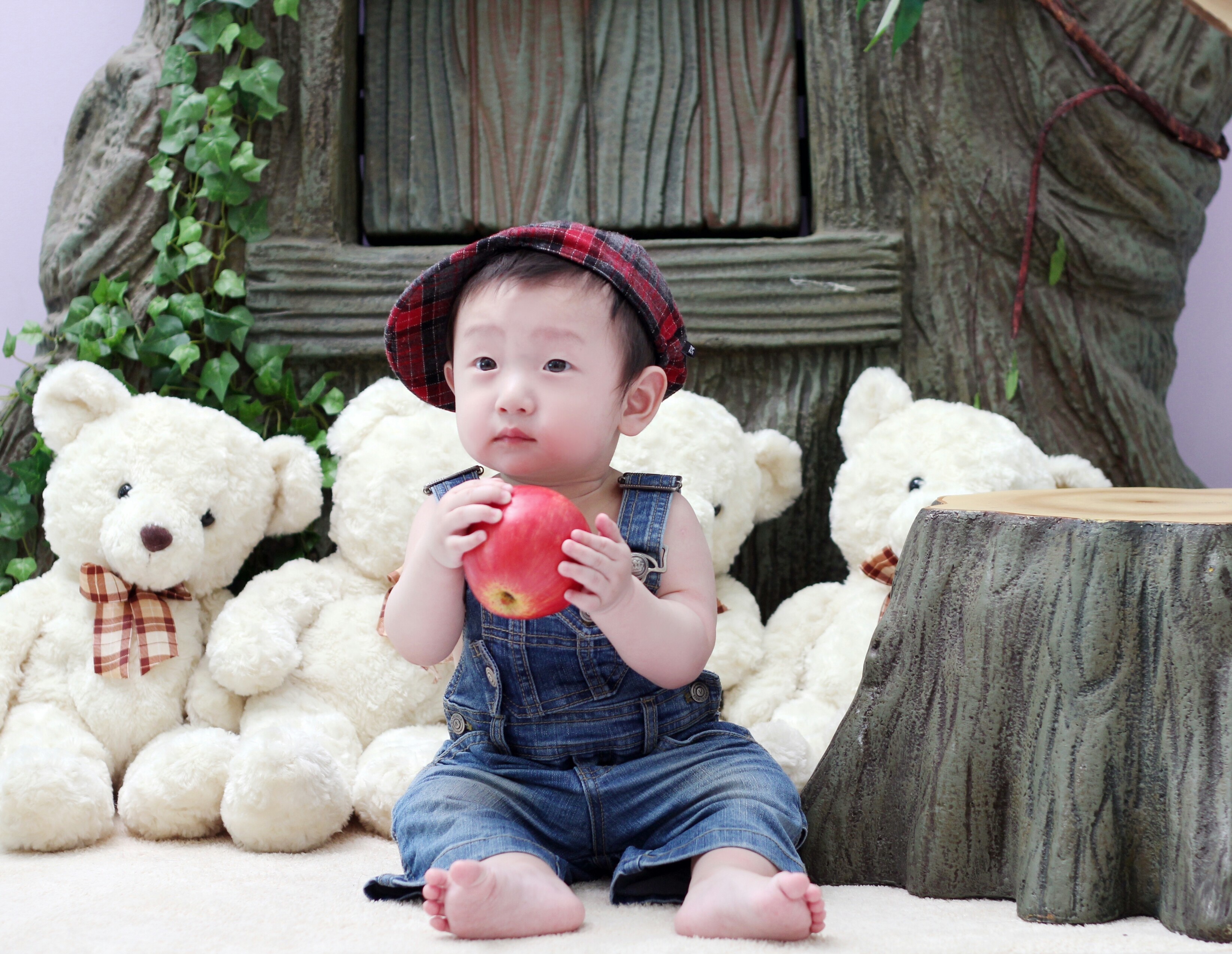 Baby boy in overalls holding an apple with teddy bears HD Wallpaper