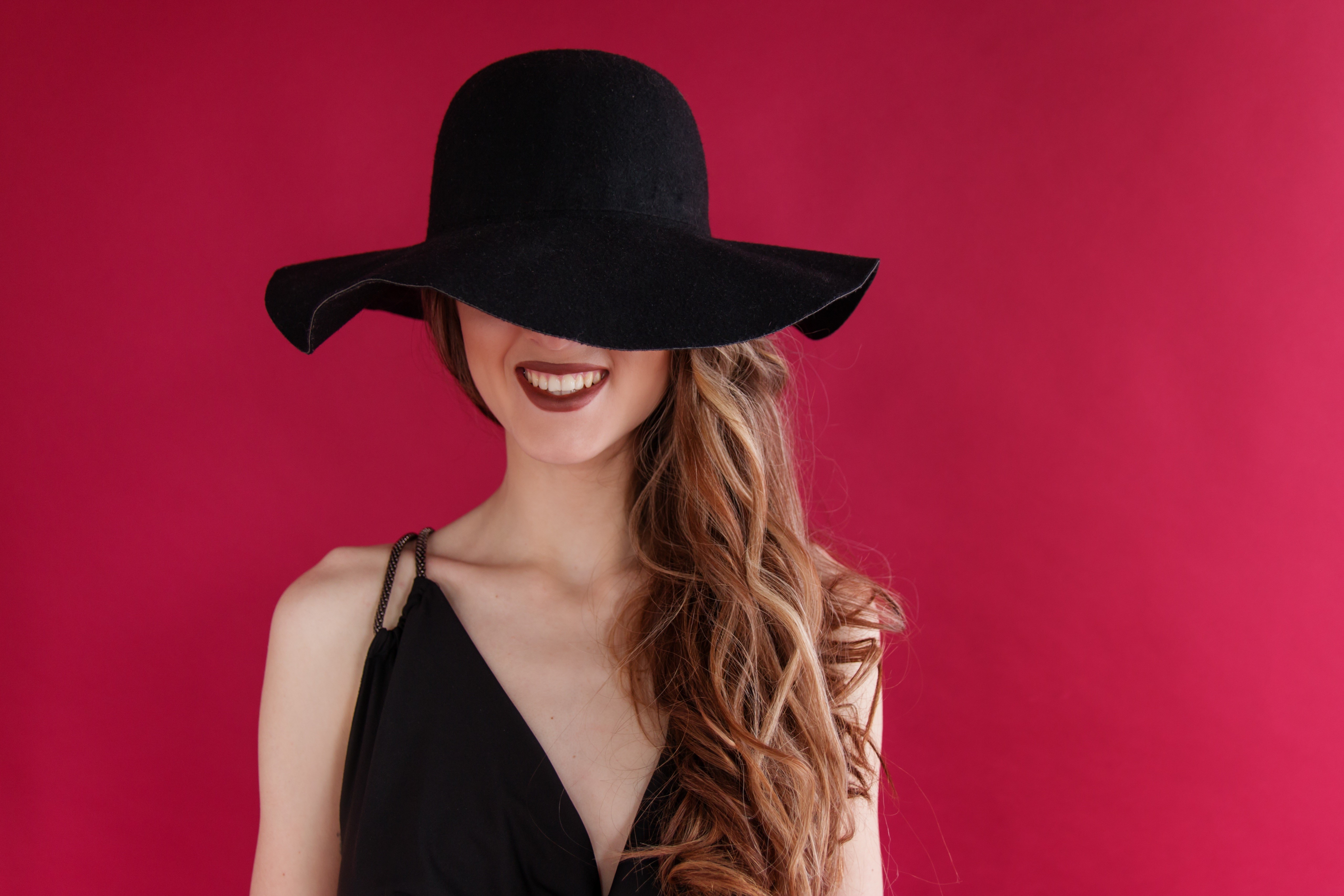 Woman in black hat and dress on red background HD Wallpaper