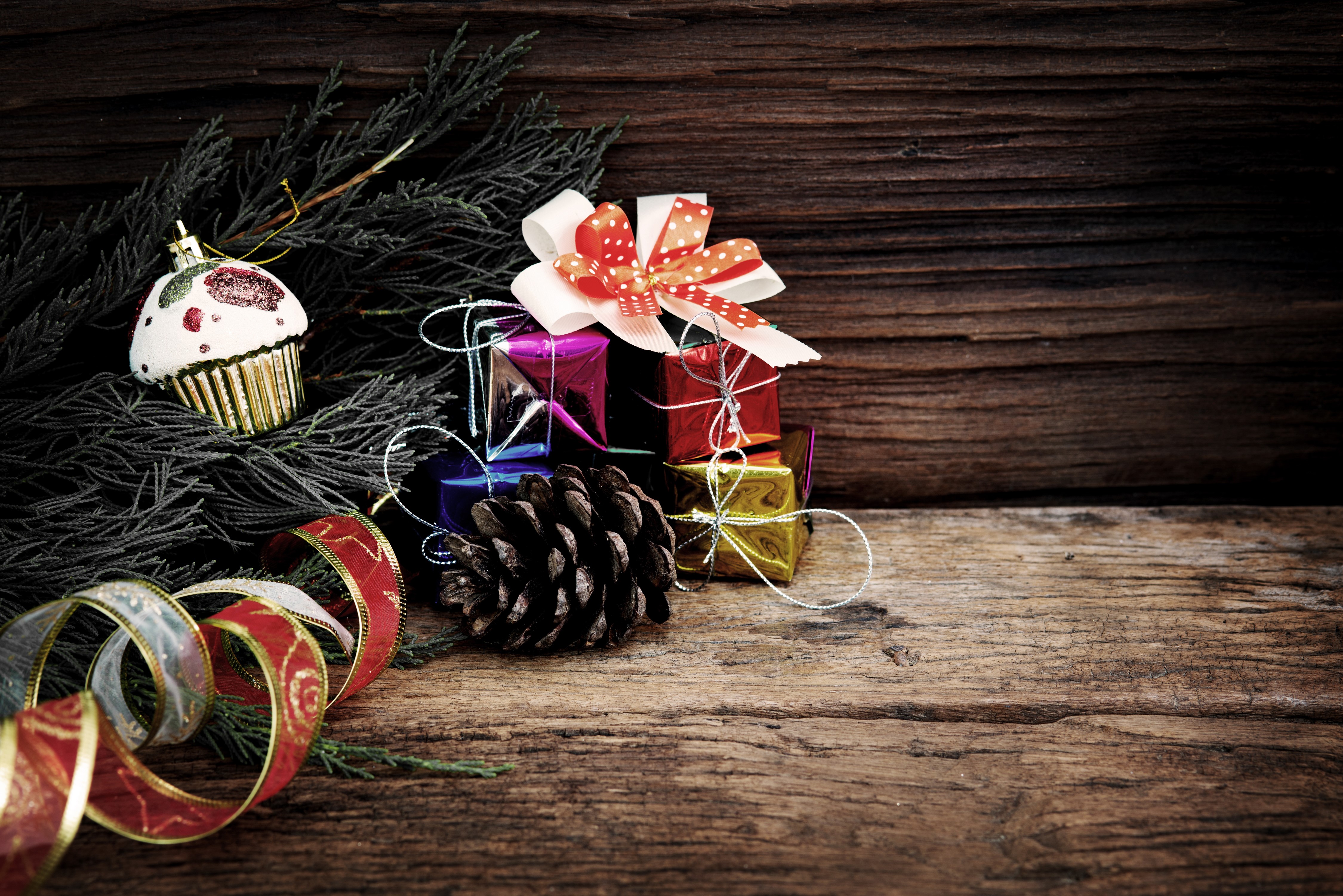 Christmas ornaments, gifts, and pine cone on wood HD Wallpaper