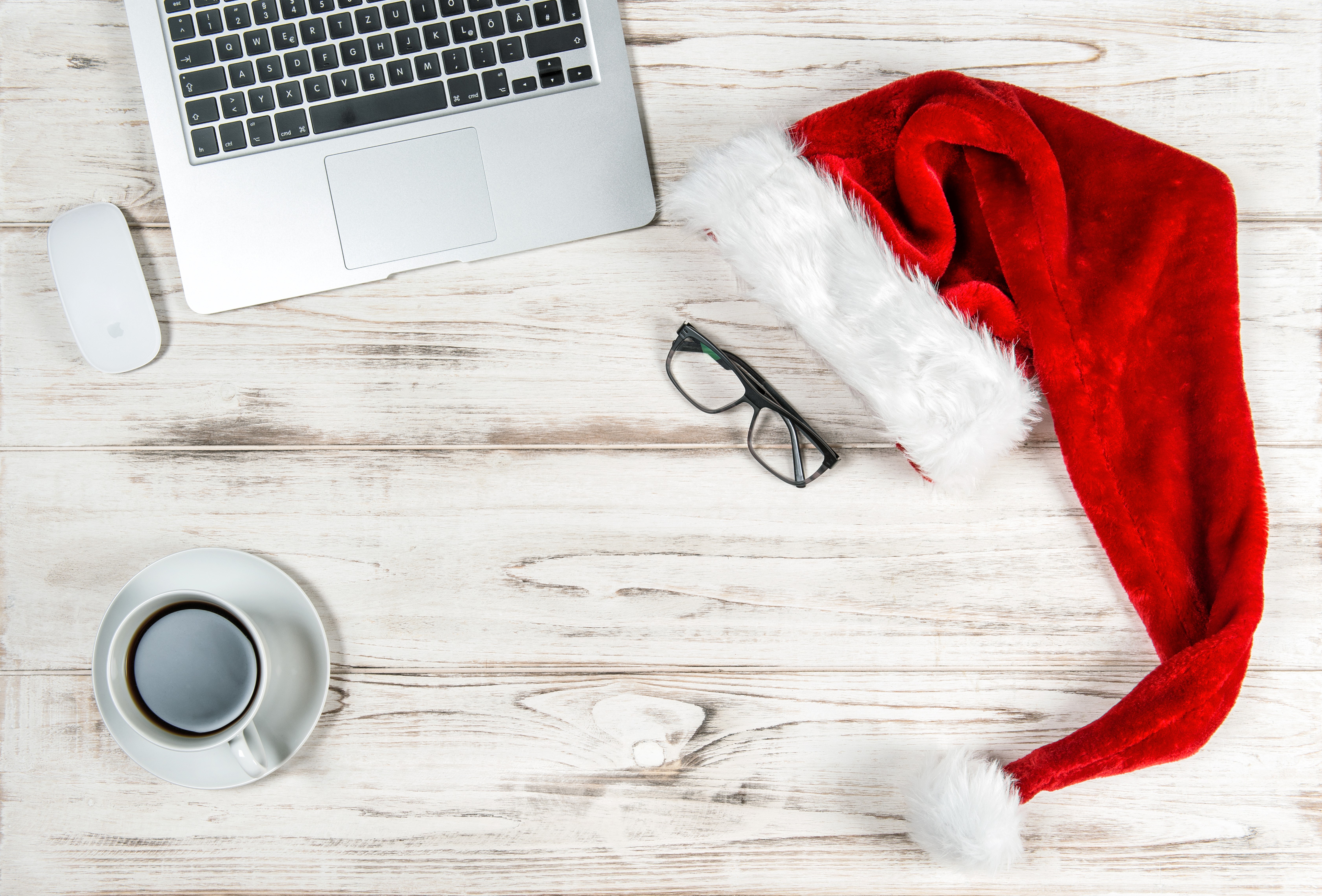 Christmas Santa hat on a wooden desk with laptop, mouse, coffee, and glasses HD Wallpaper