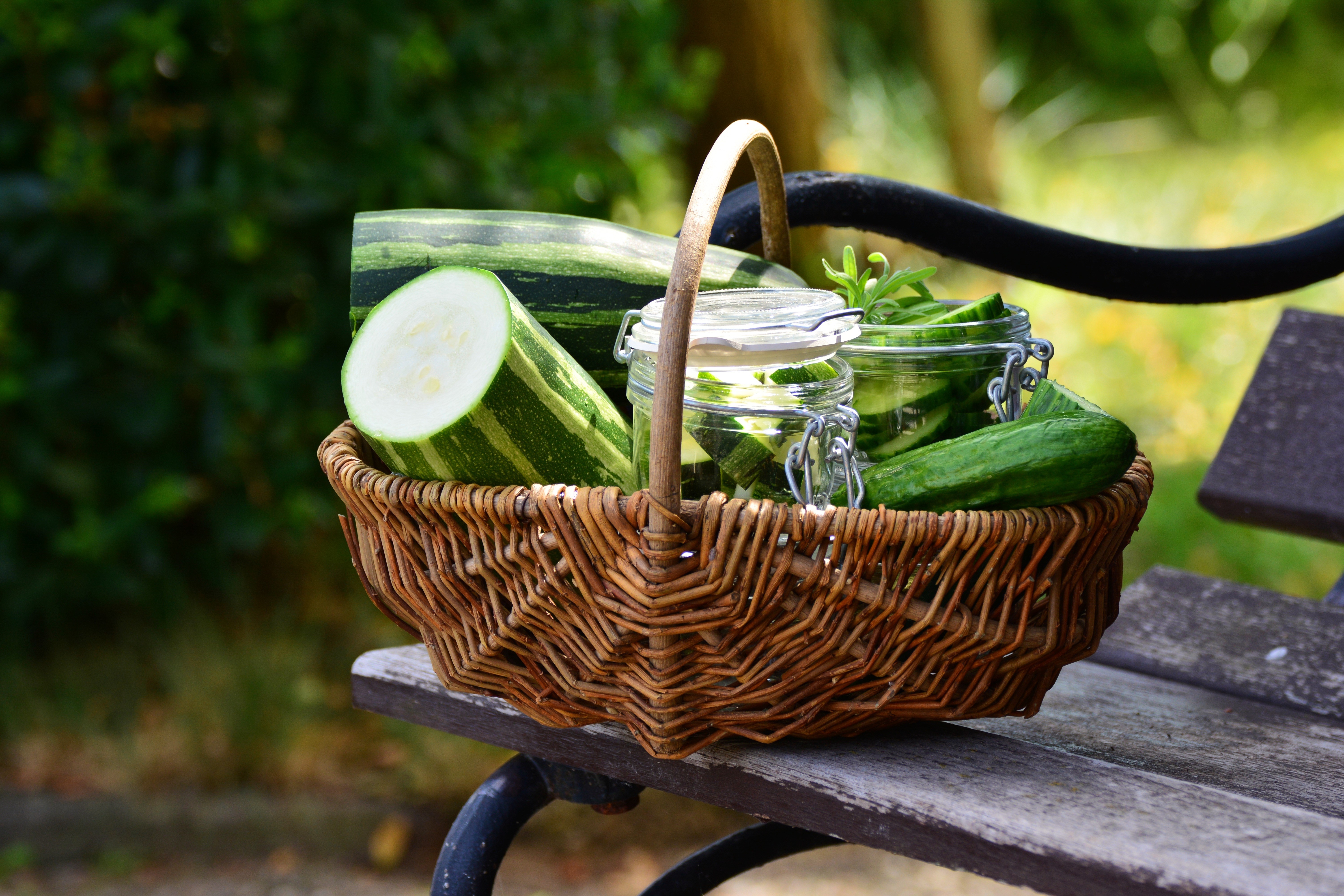Cucumbers in a wicker basket on a bench HD Wallpaper