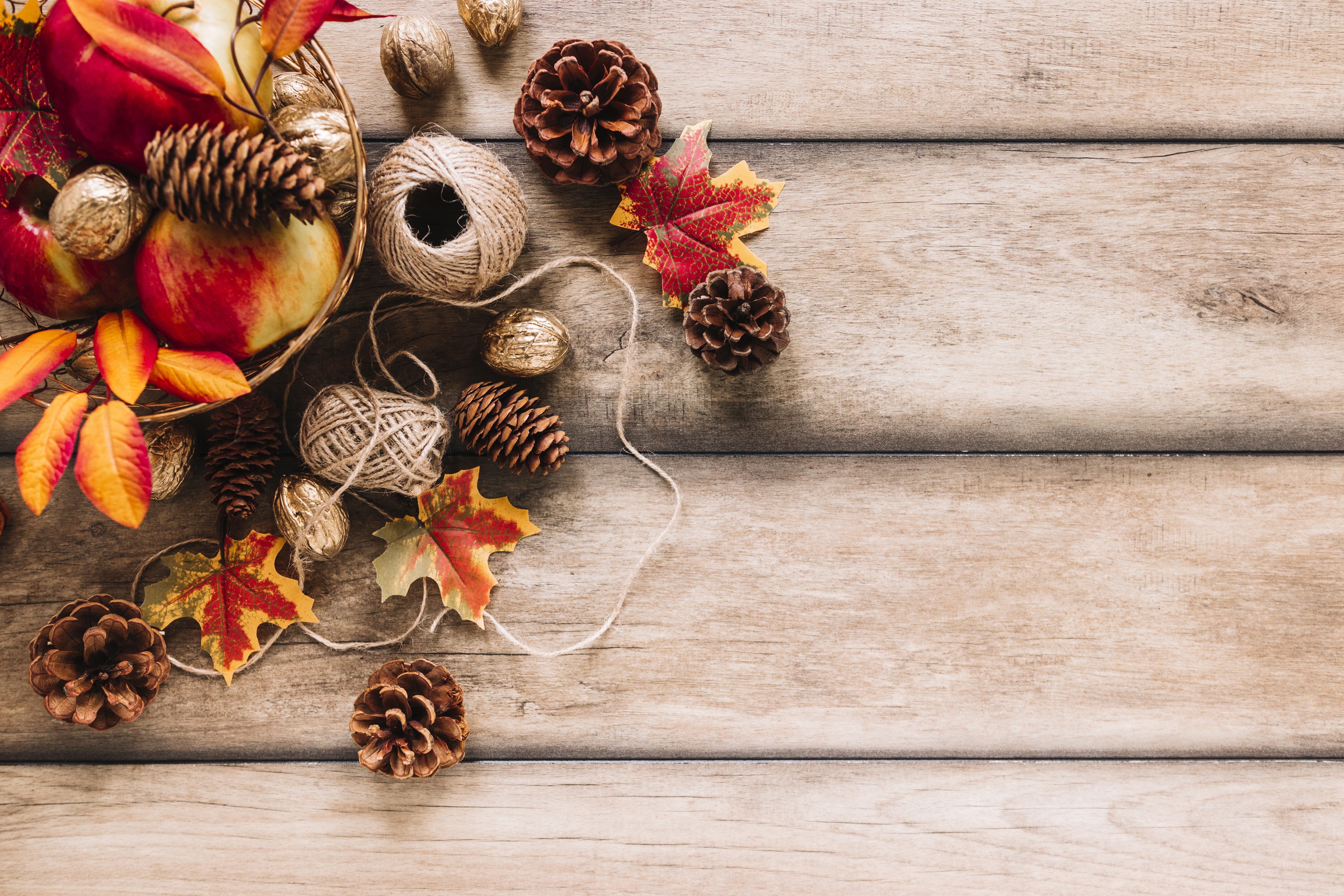 Autumn harvest arrangement with apples, pine cones, and twine HD Wallpaper