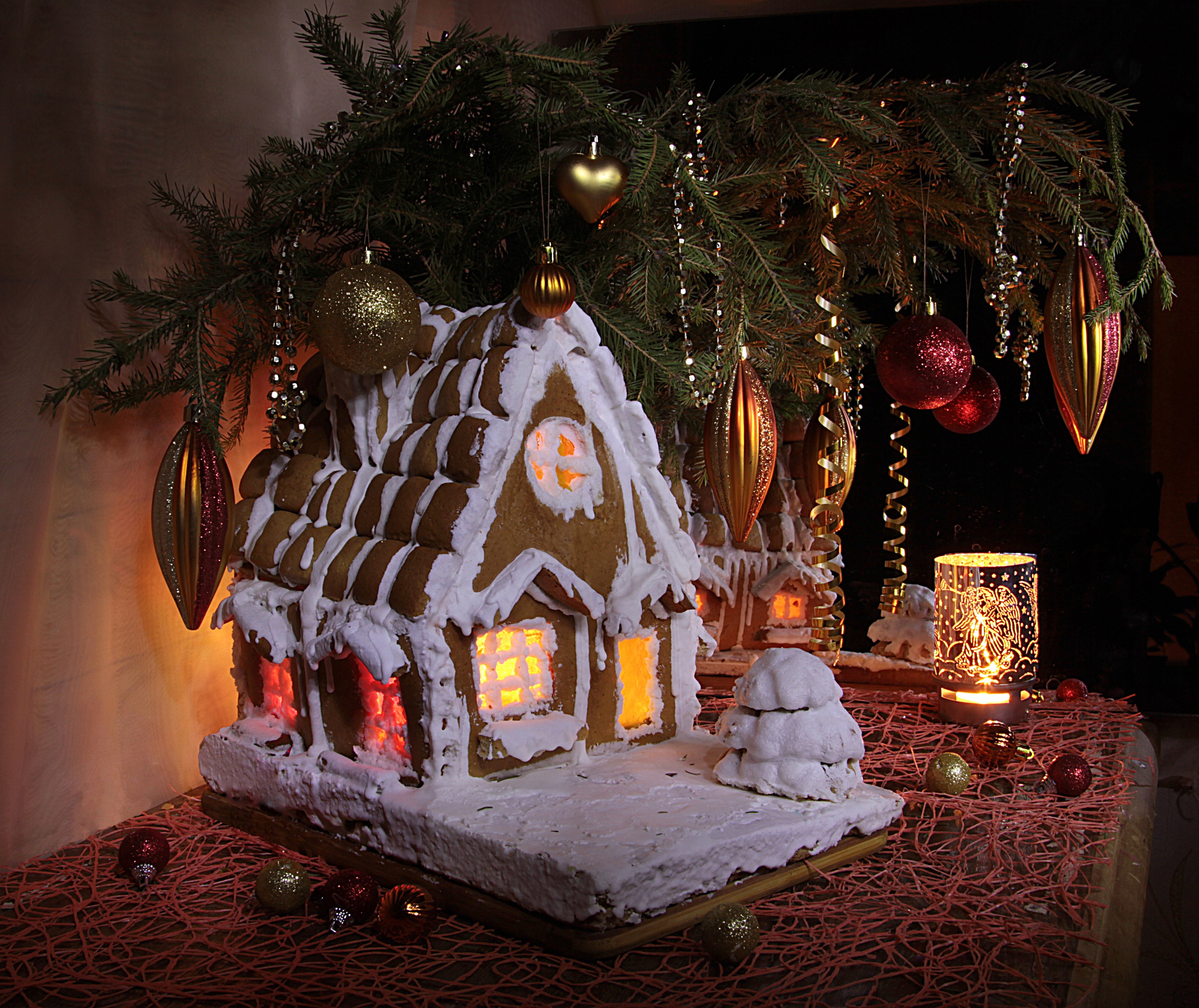 Gingerbread houses decorated for Christmas with ornaments and pine branches HD Wallpaper