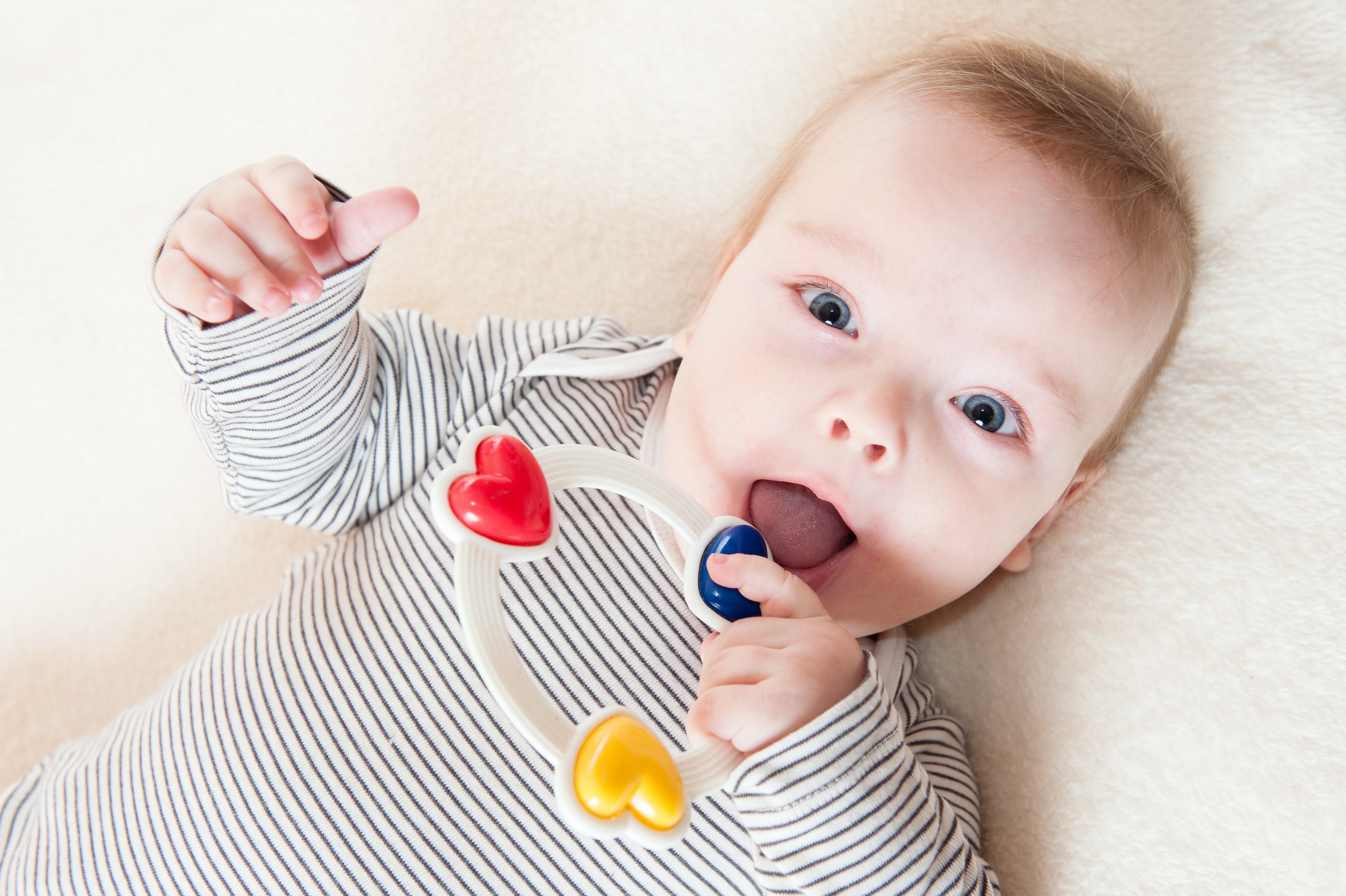 Infant playing with a toy rattle HD Wallpaper