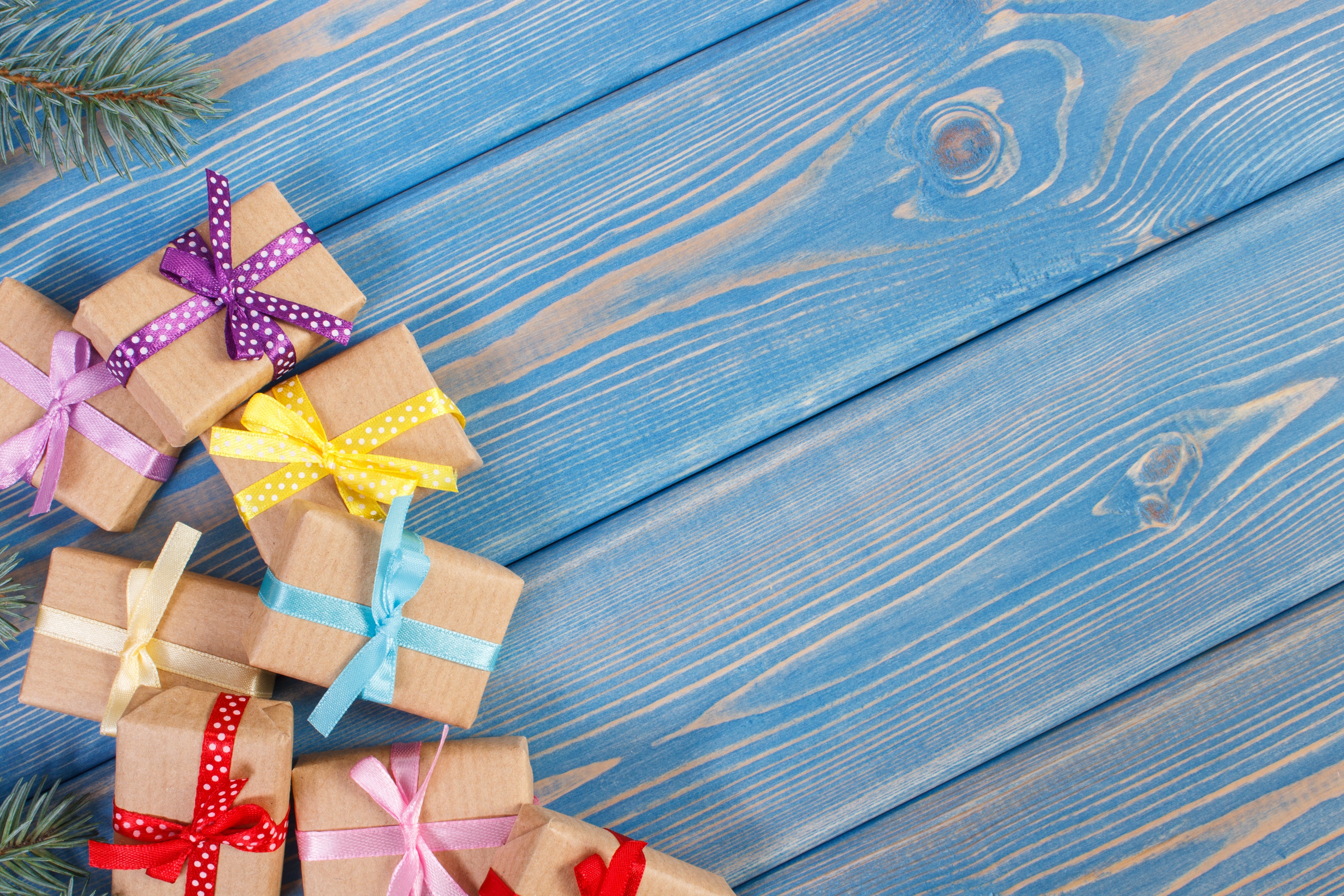Christmas gifts with colorful ribbons on blue wood planks HD Wallpaper