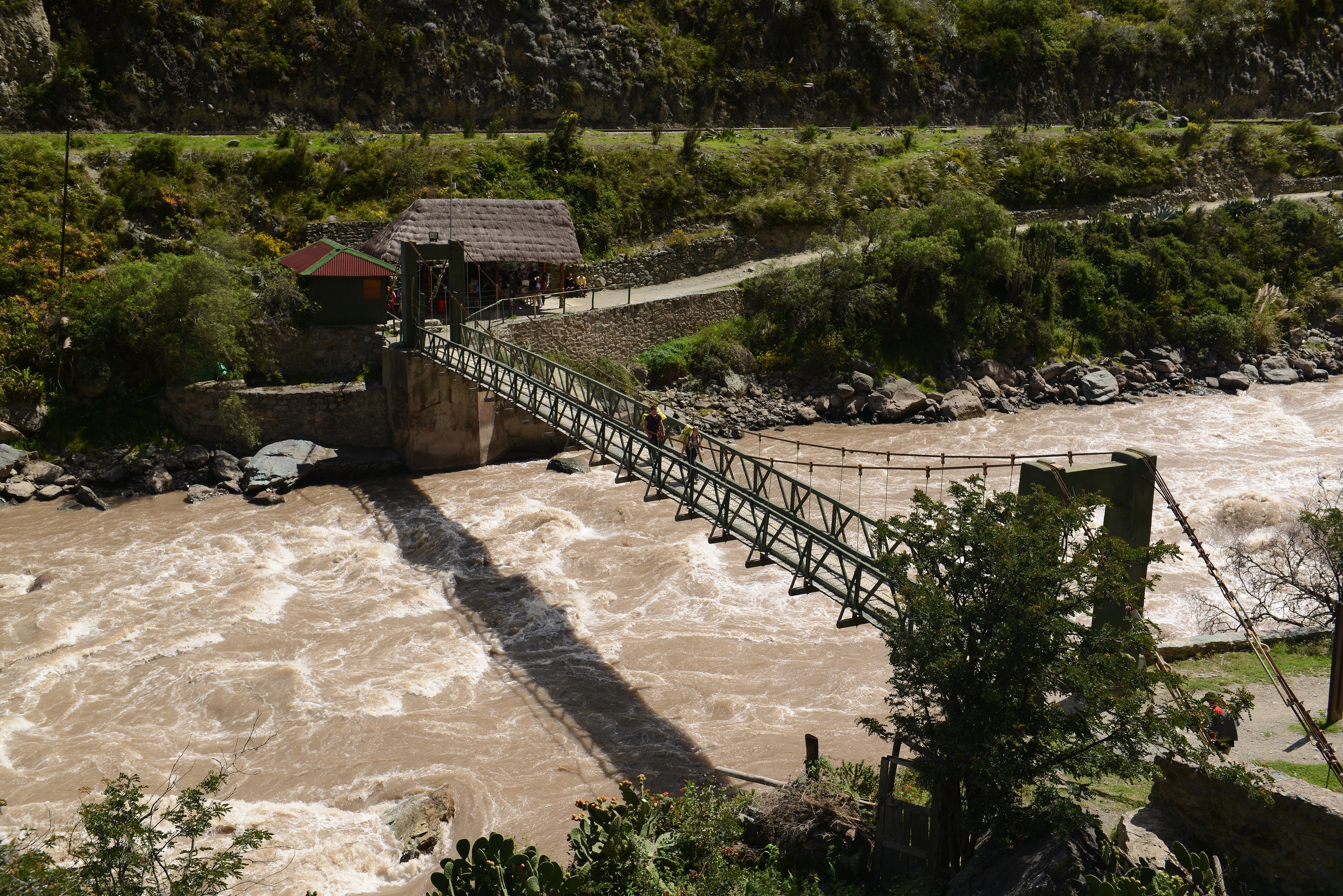 Suspension bridge over a muddy river on the Inca Trail HD Wallpaper