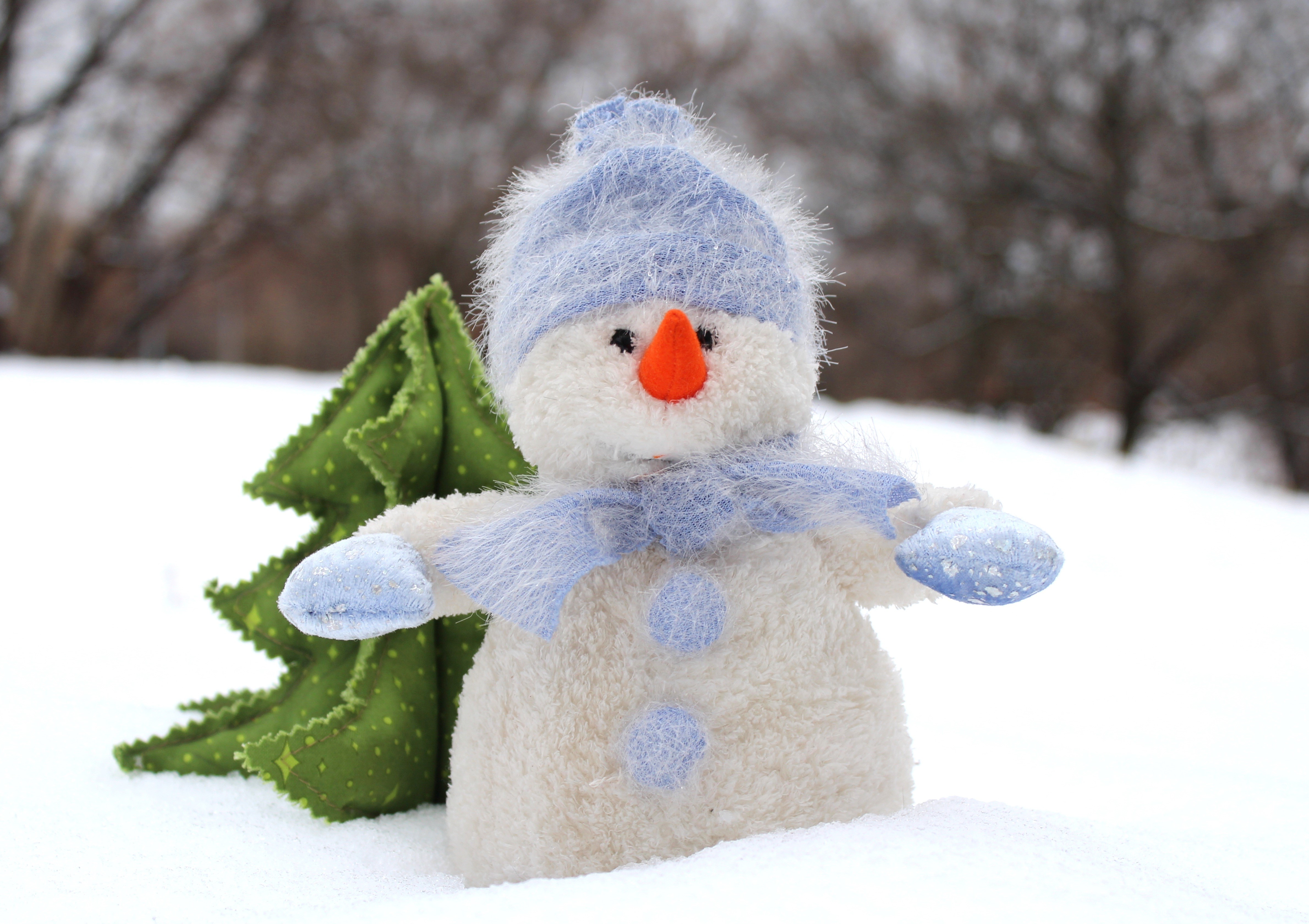 Plush snowman with a green tree in the snow HD Wallpaper