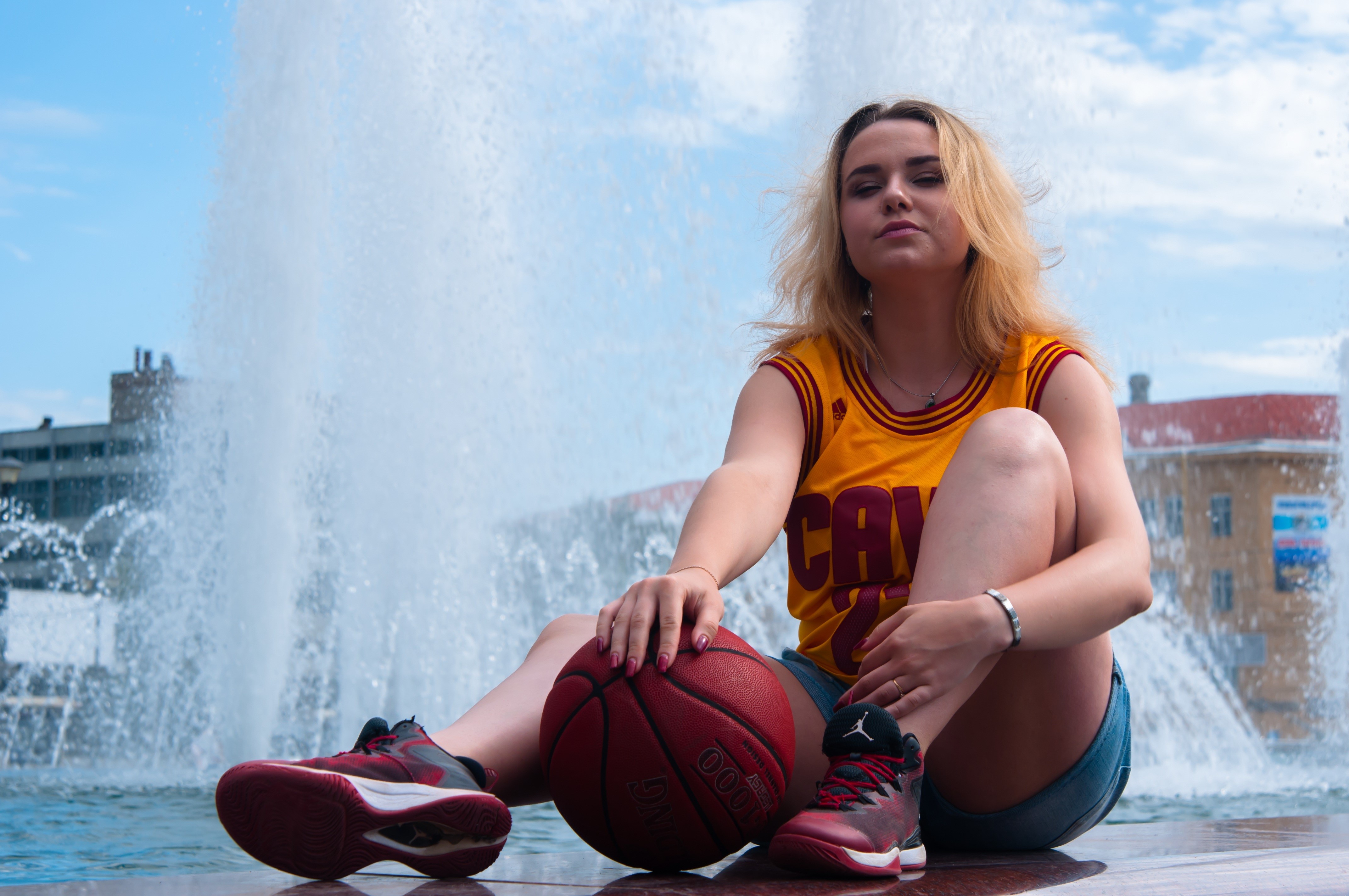 Blonde girl with basketball sitting by fountain HD Wallpaper