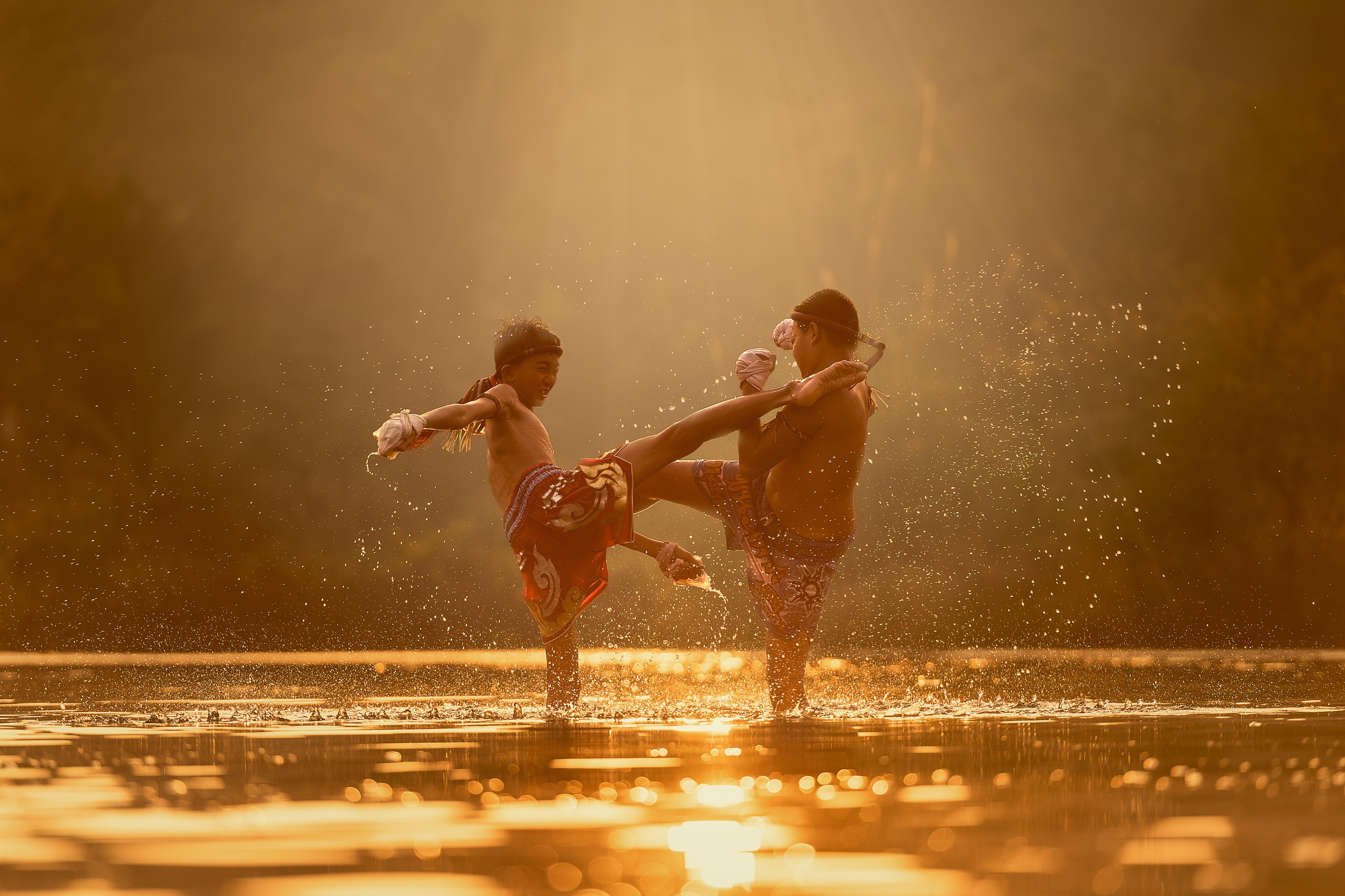 Two boys practicing Muay Thai in a river HD Wallpaper