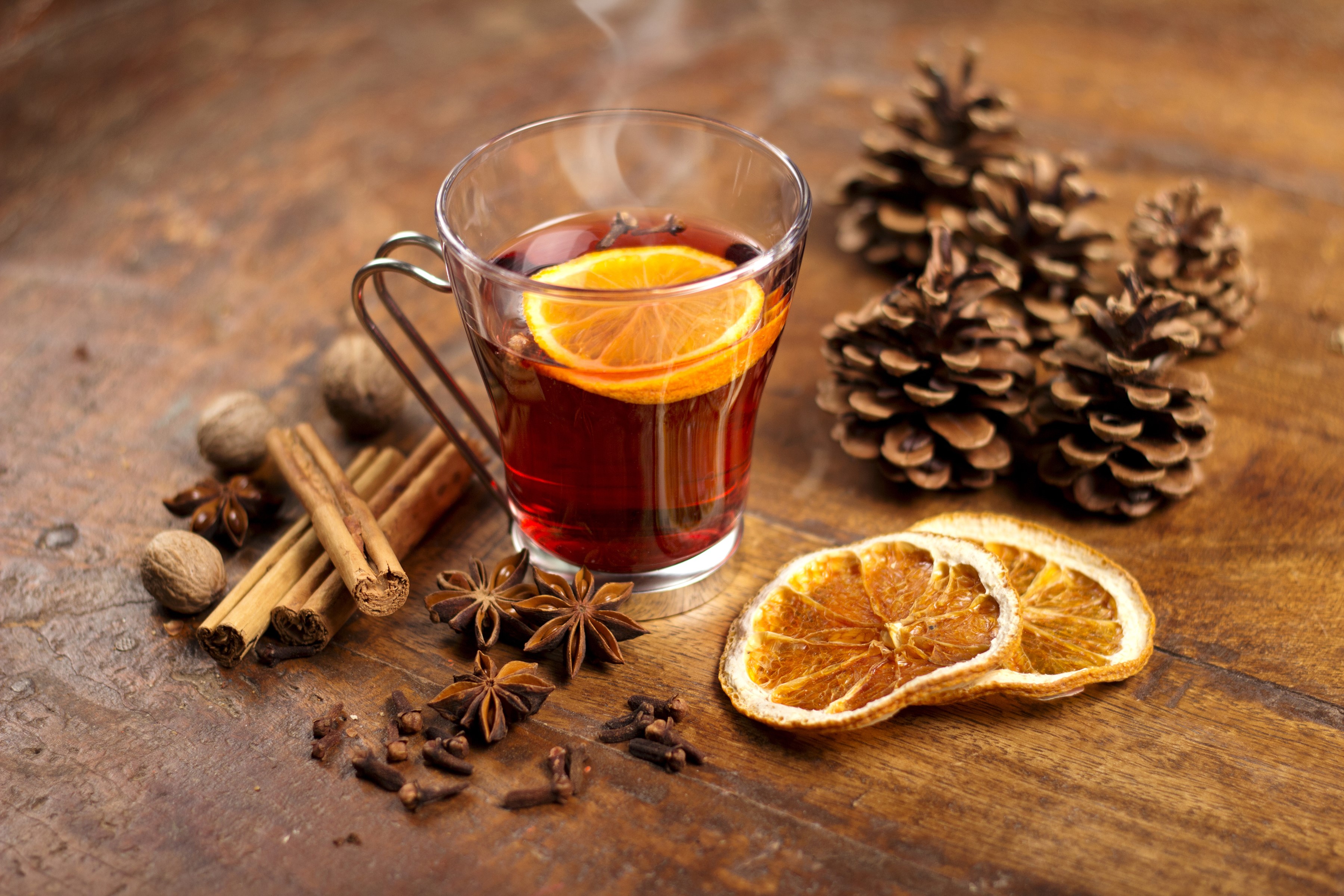 Hot drink with orange, cinnamon, star anise, and pine cones HD Wallpaper