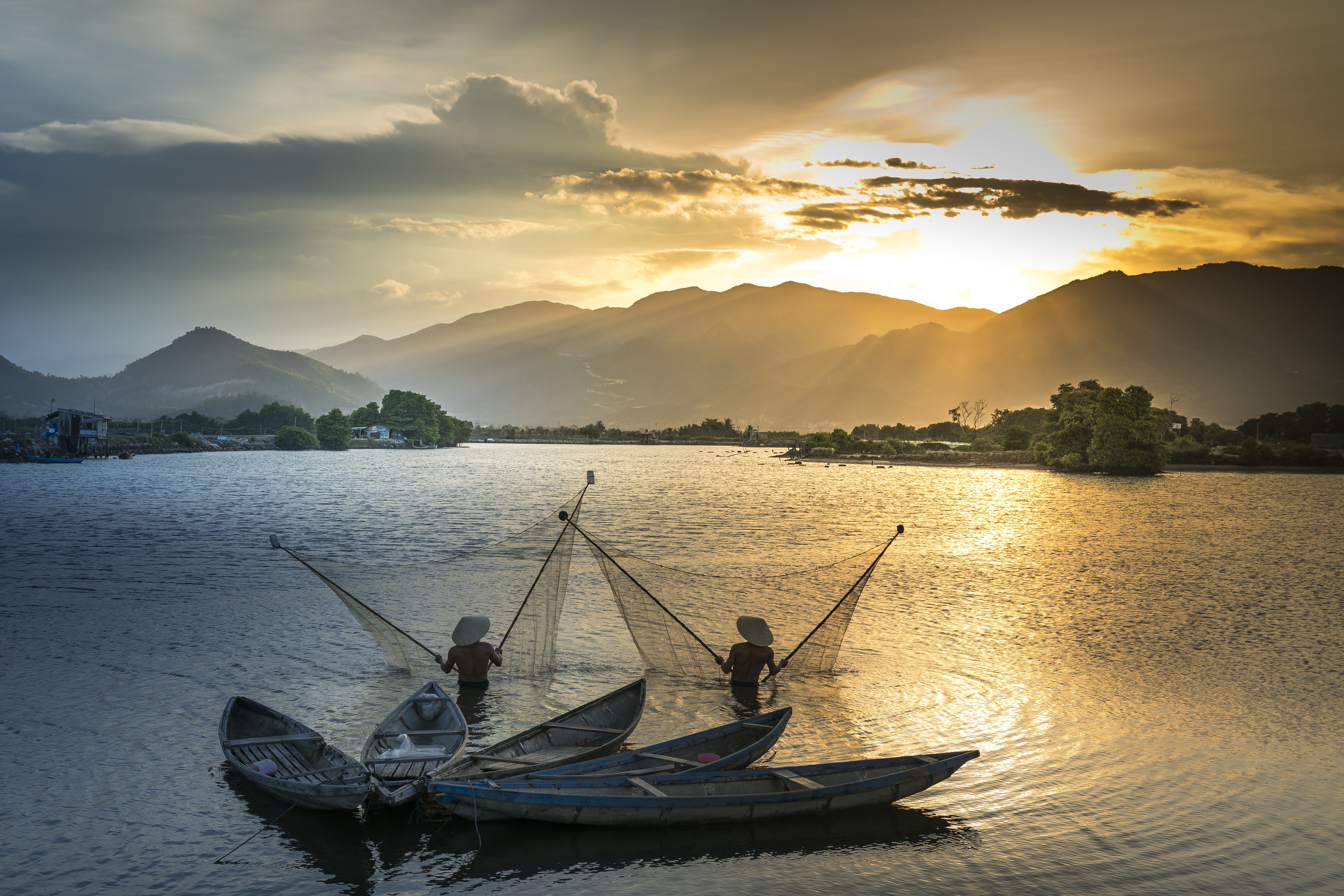 Two fishermen in boats with nets at sunset HD Wallpaper