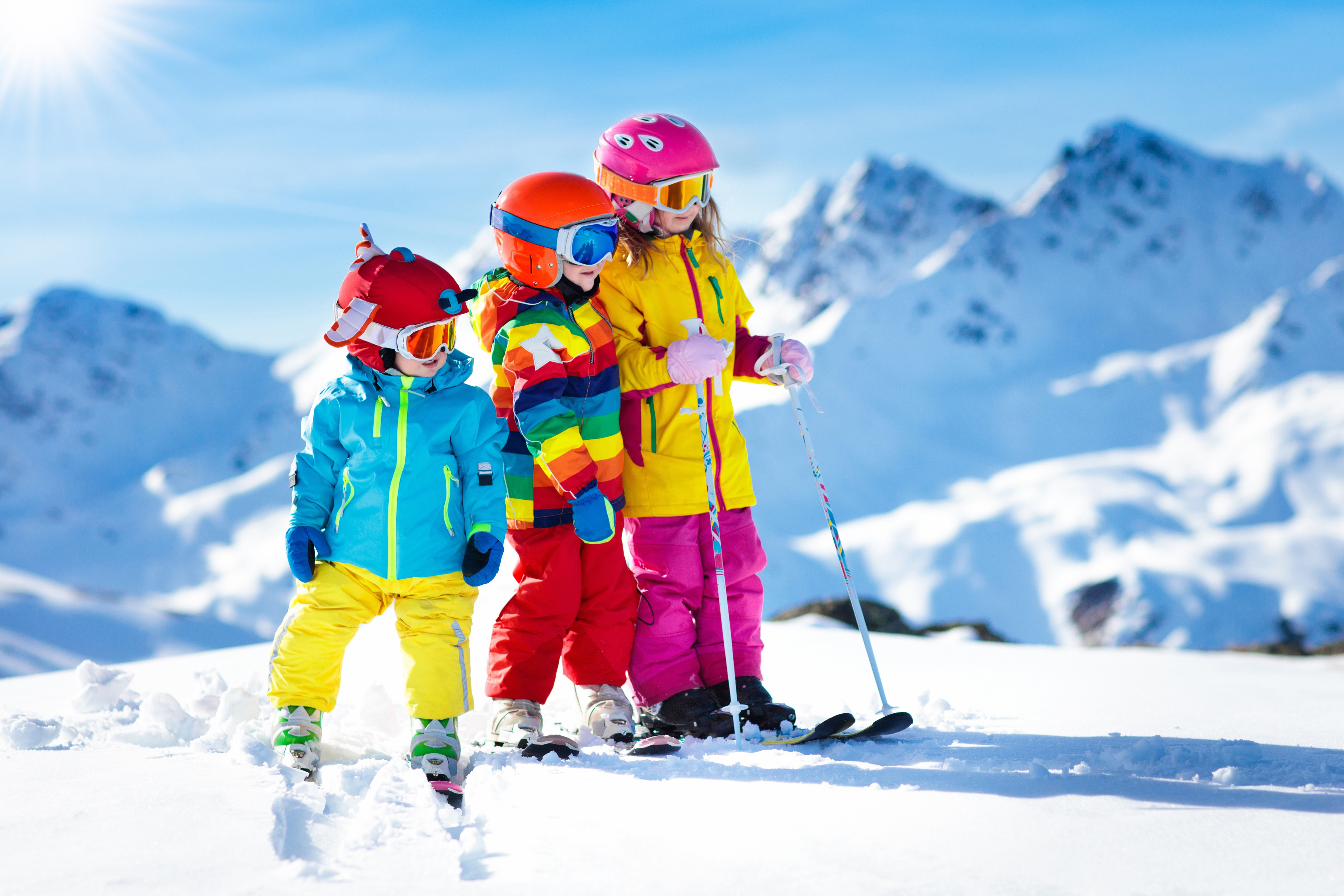 Three Children in Ski Gear on Snowy Mountain HD Wallpaper
