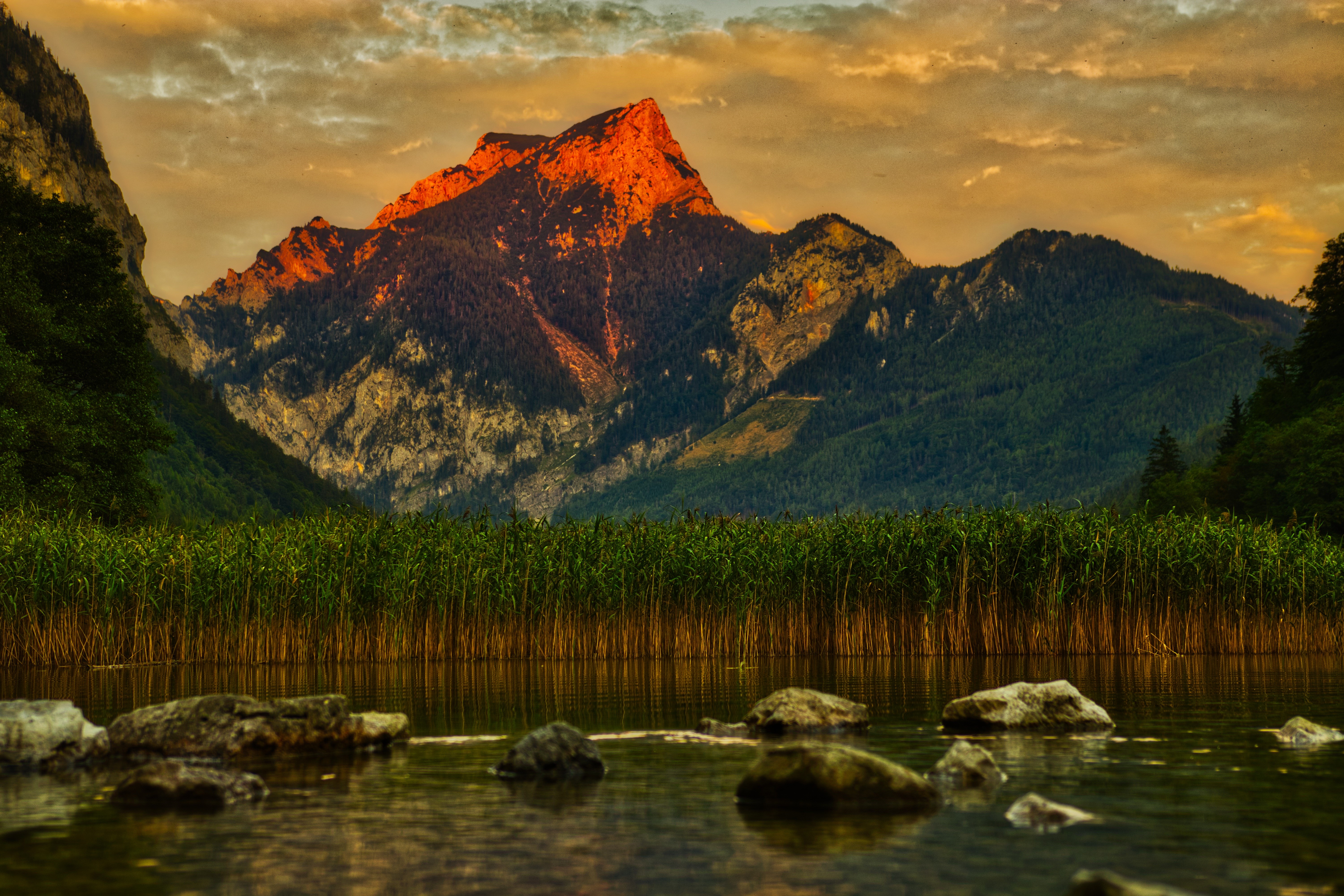 Mountain peak illuminated by sunset over a lake in Styria, Austria HD Wallpaper
