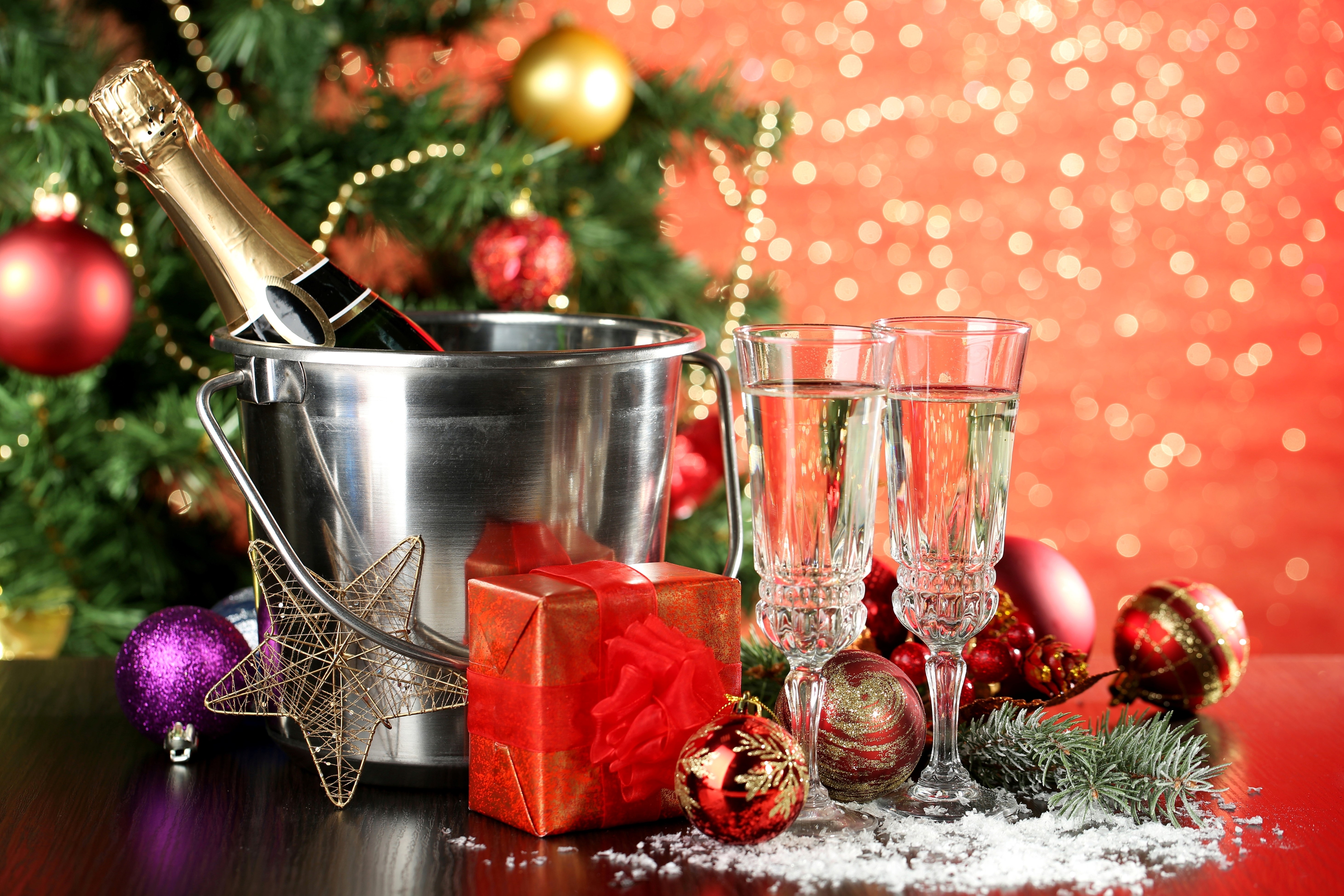 Champagne bottle in ice bucket with glasses and Christmas tree HD Wallpaper