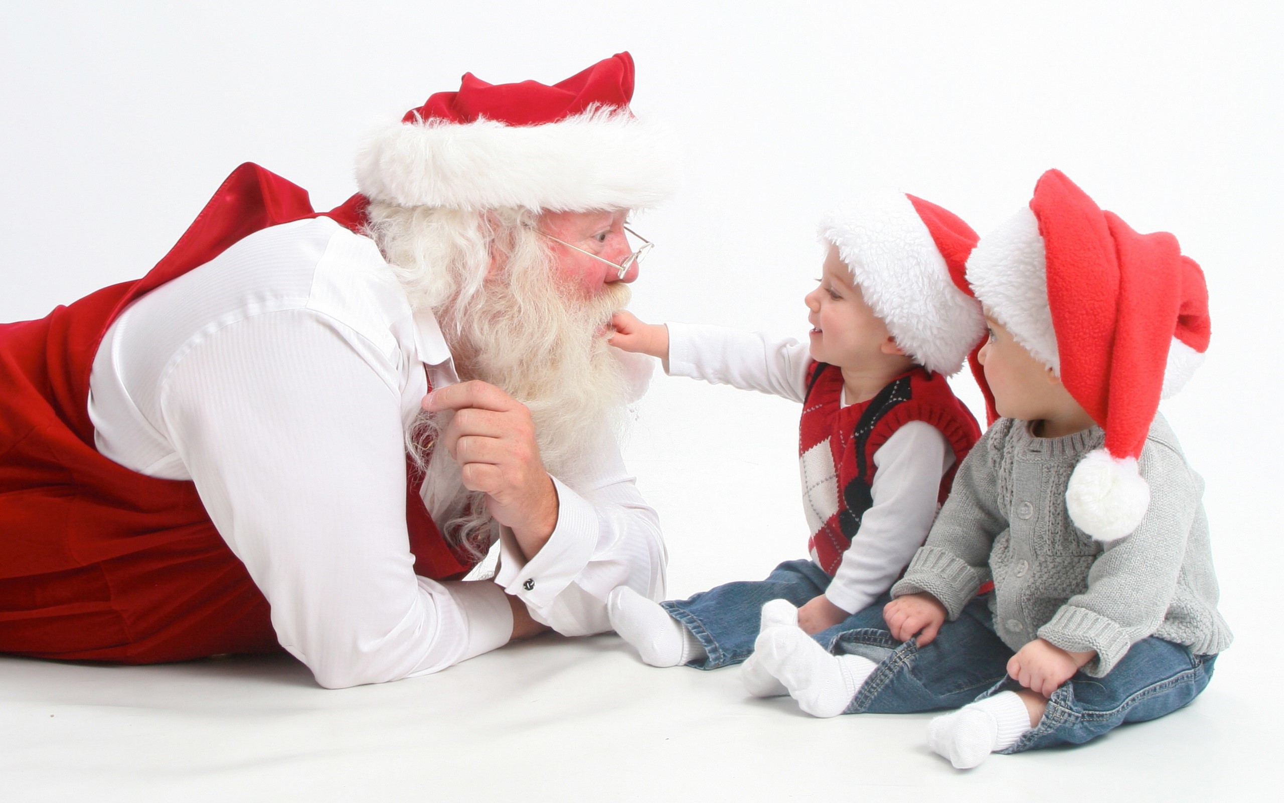 Santa Claus with two babies wearing Santa hats HD Wallpaper