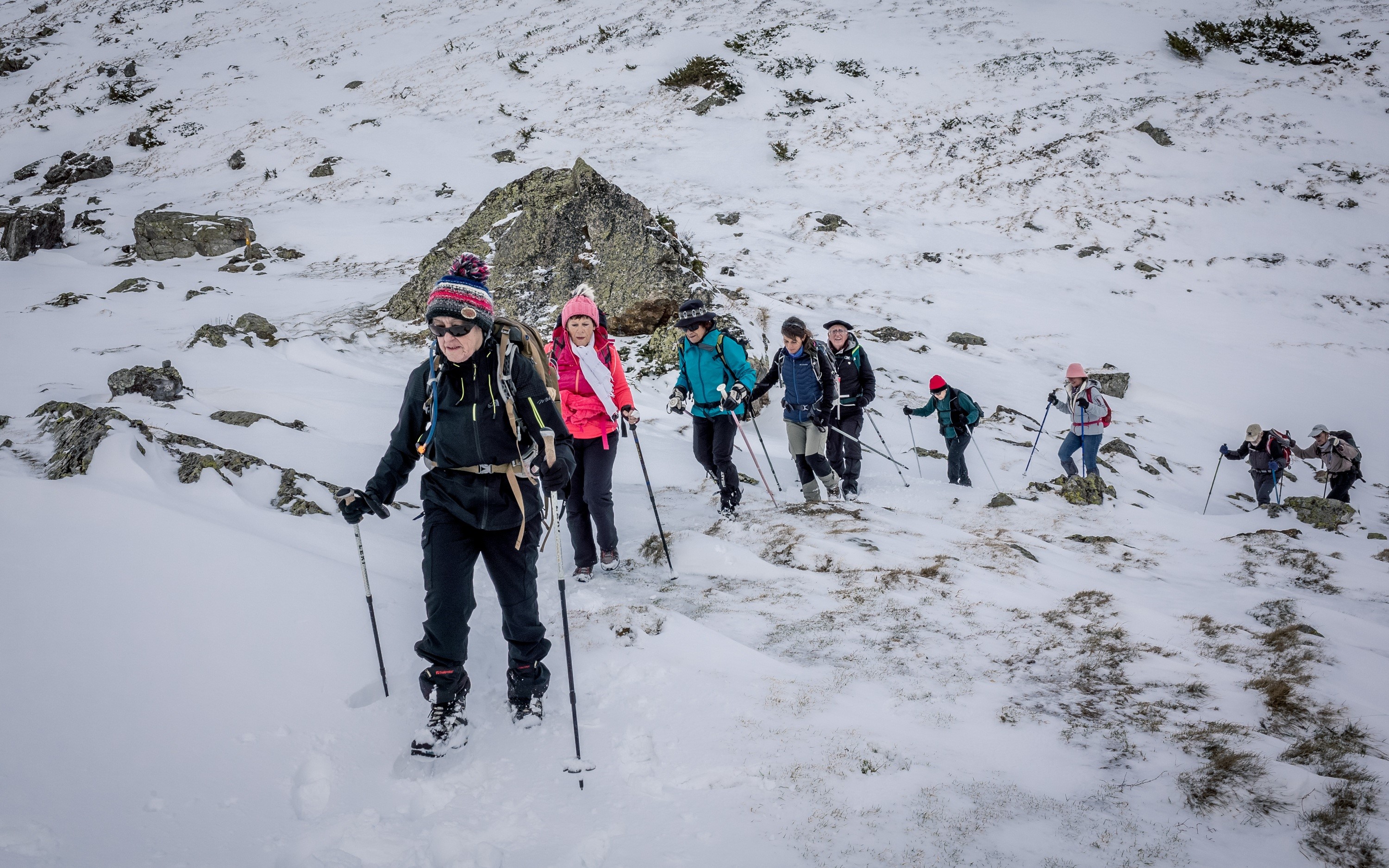 Group hiking in the snowy Pyrenees Mountains HD Wallpaper