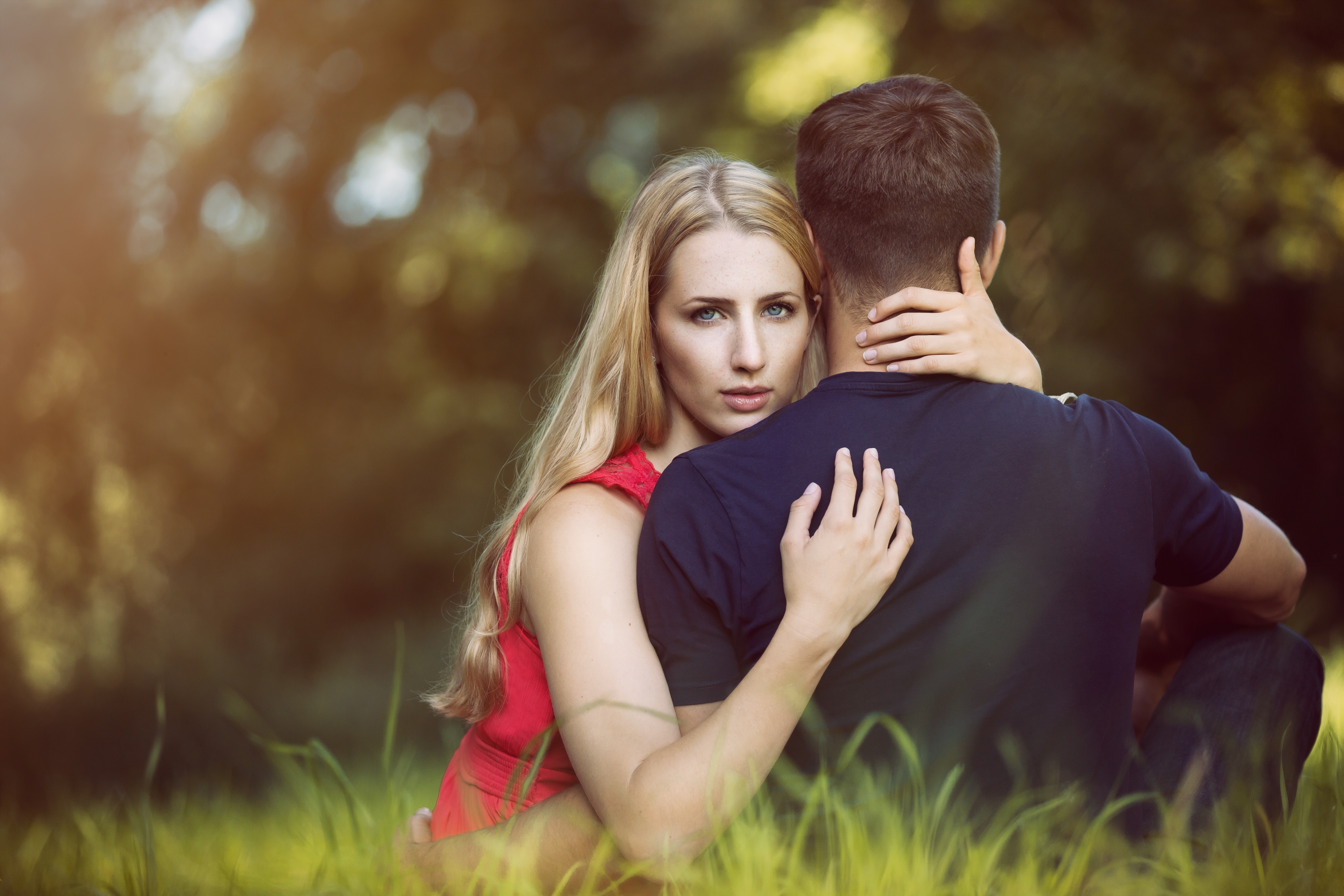 Couple hugging in a grassy field HD Wallpaper
