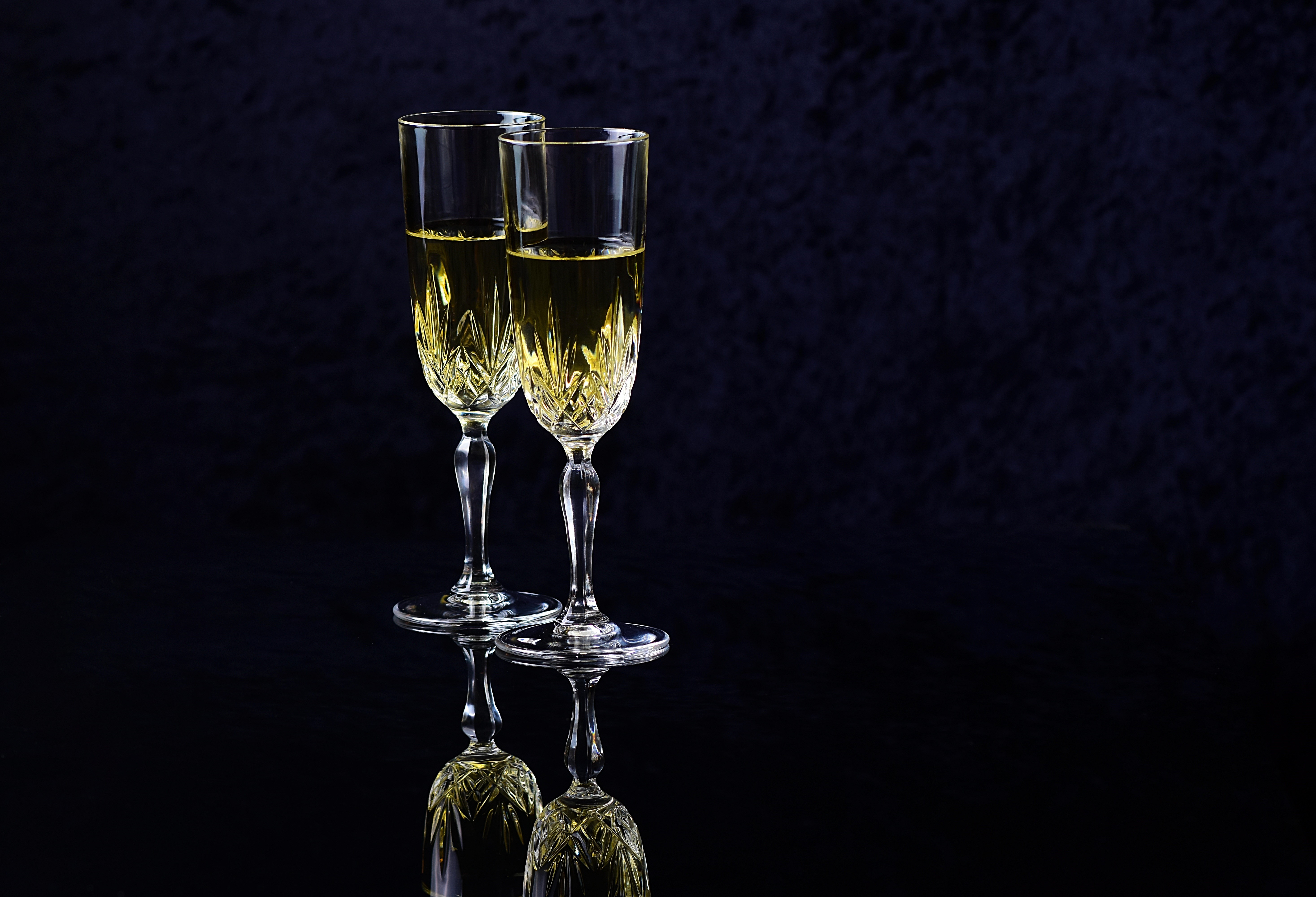 Two champagne glasses with champagne on black background HD Wallpaper