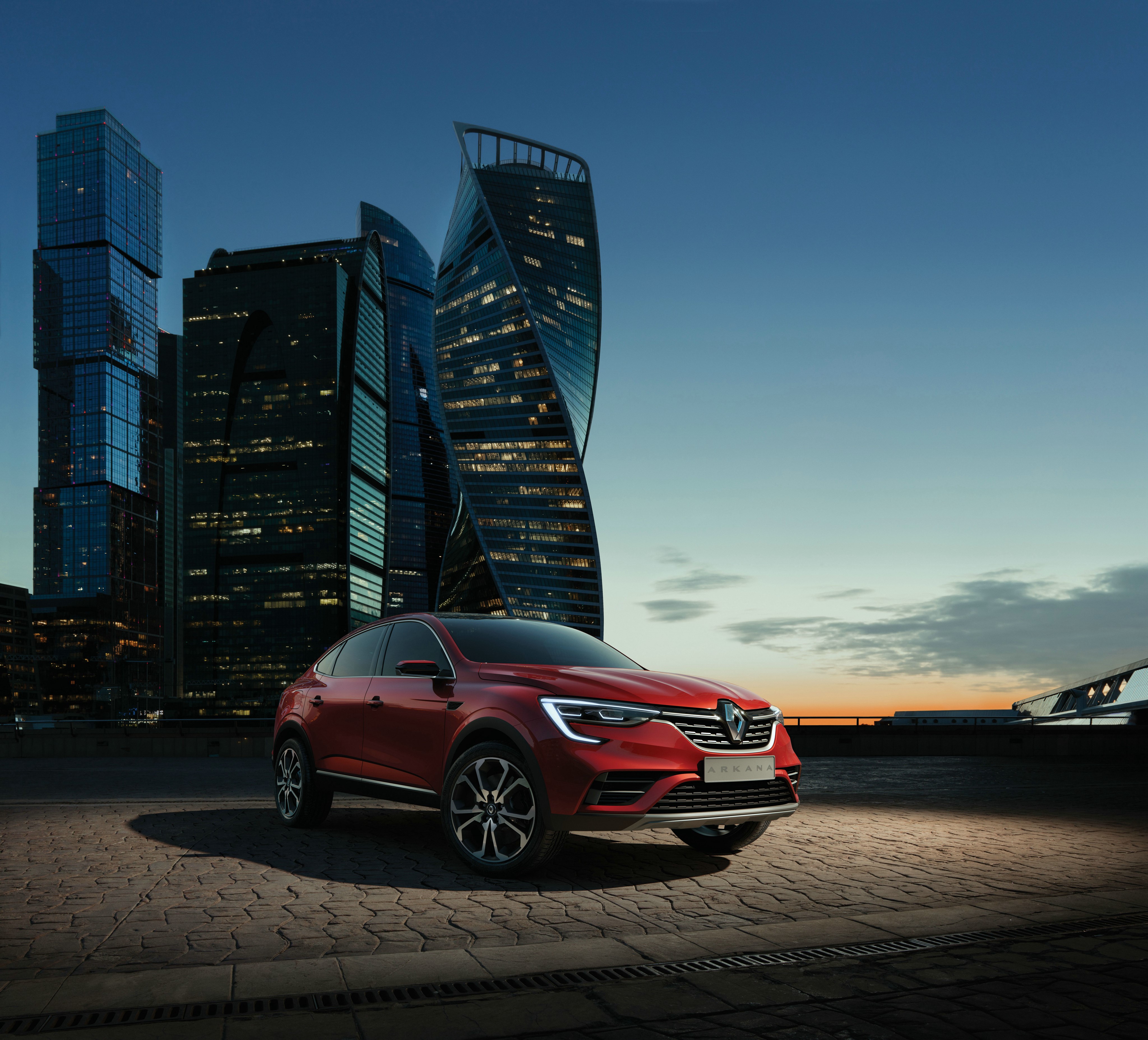 Red Renault Arkana in front of modern skyscrapers HD Wallpaper