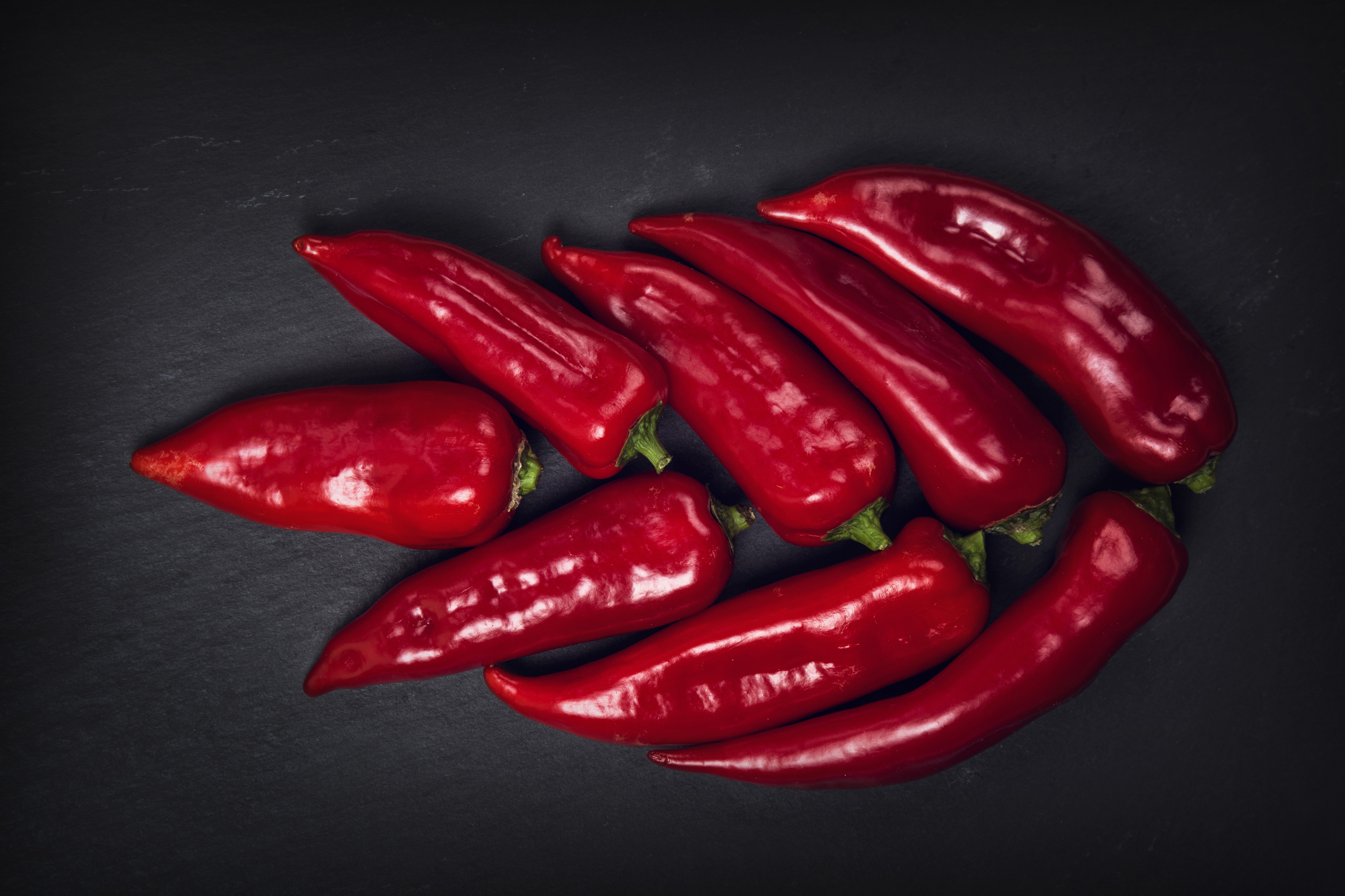 Red chili peppers on a dark surface HD Wallpaper