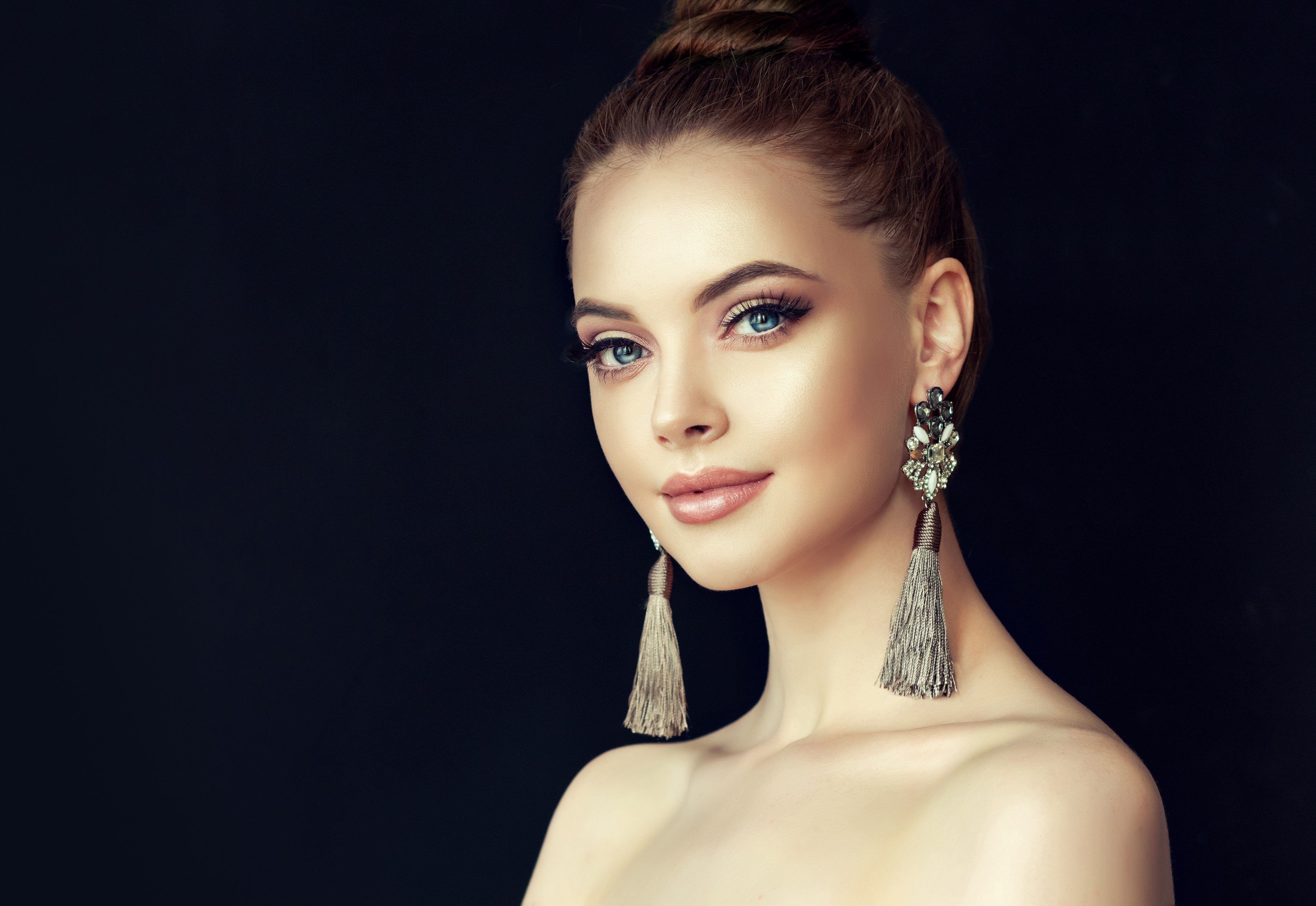 Woman with brown hair and earrings on black background HD Wallpaper