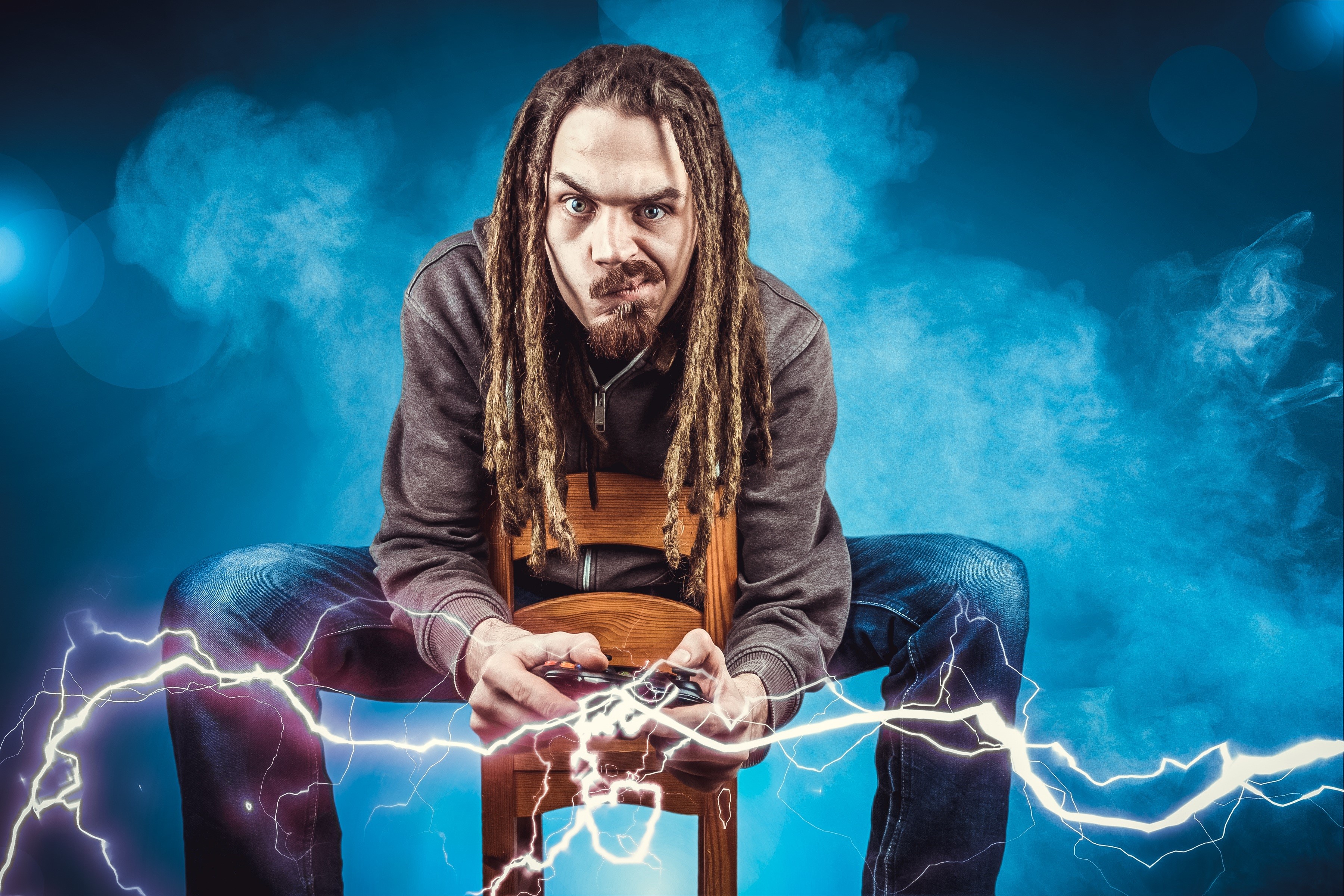 Man with dreadlocks playing video games with lightning effects HD Wallpaper