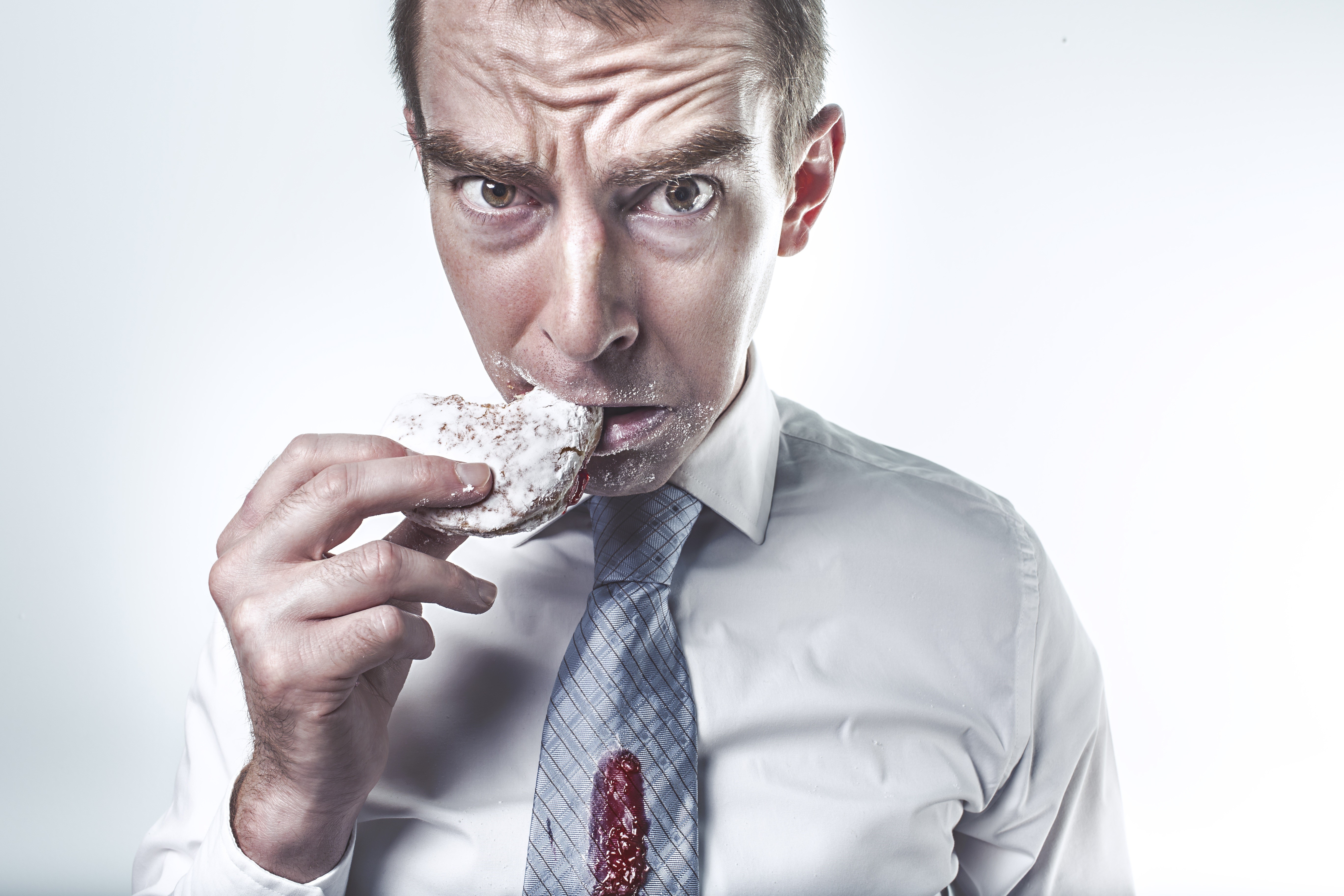Man in a white shirt eating a donut HD Wallpaper