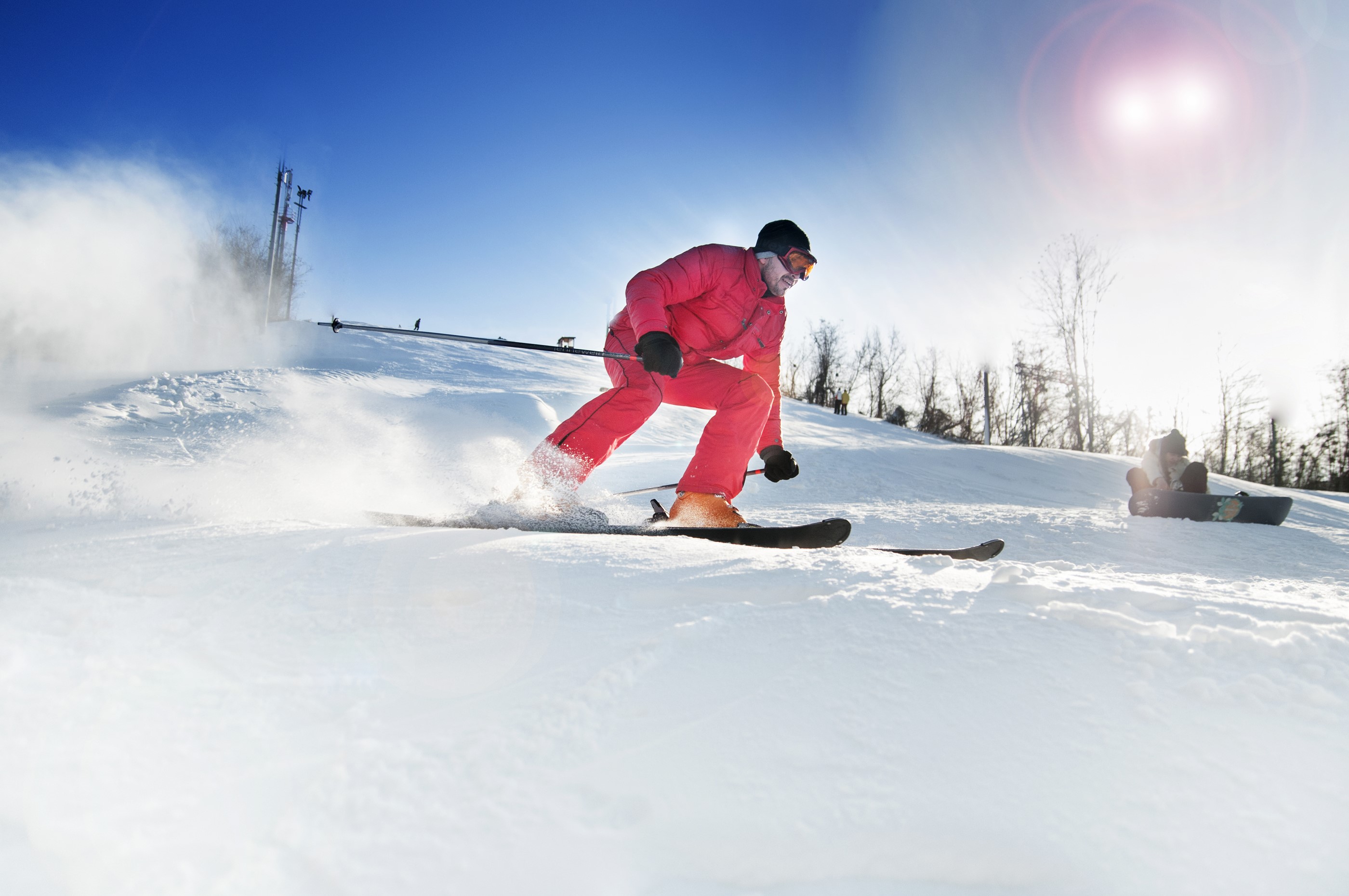 Man skiing down a snowy slope on a sunny day HD Wallpaper