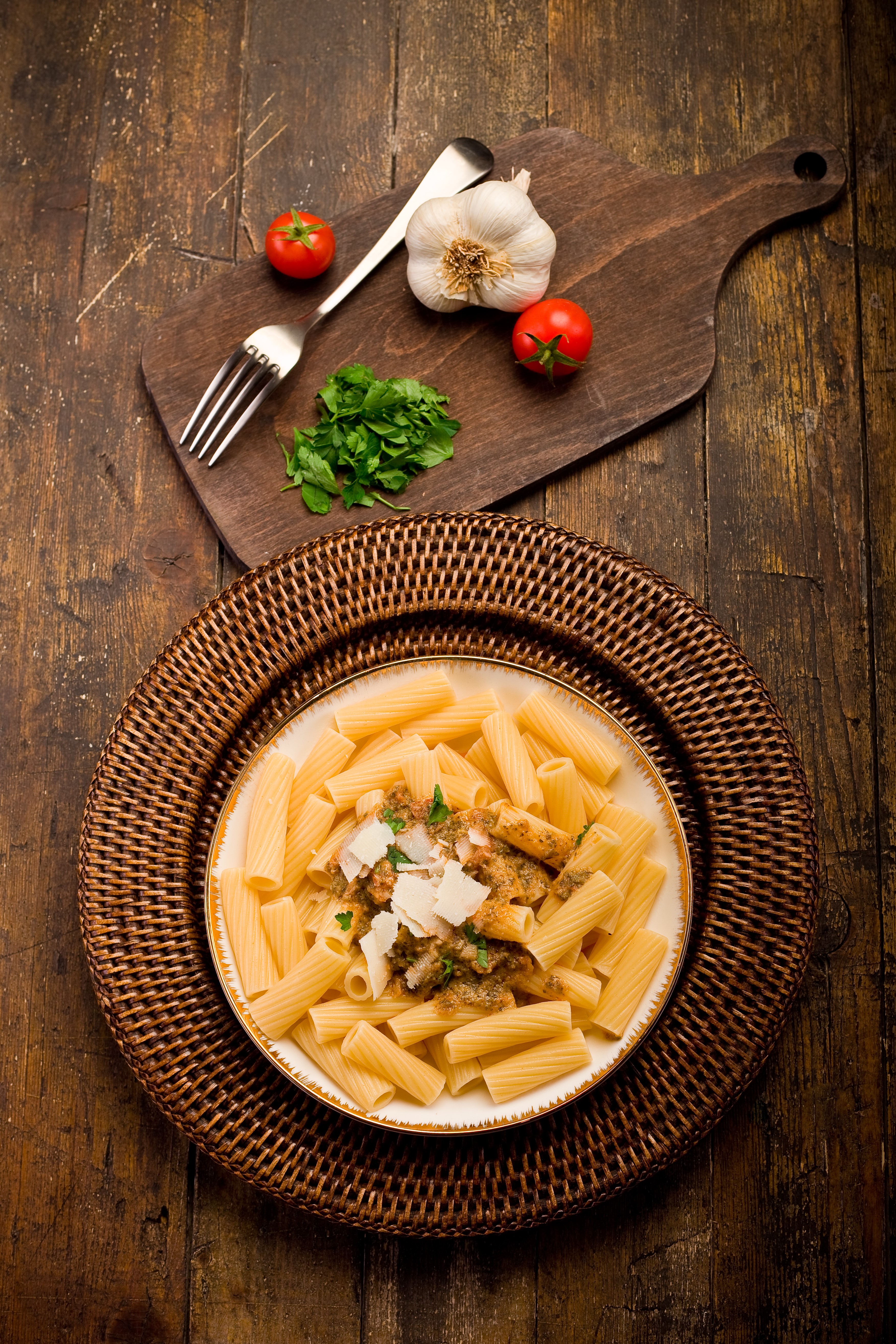 Pasta with tomatoes, garlic, and parsley on a cutting board HD Phone Wallpaper