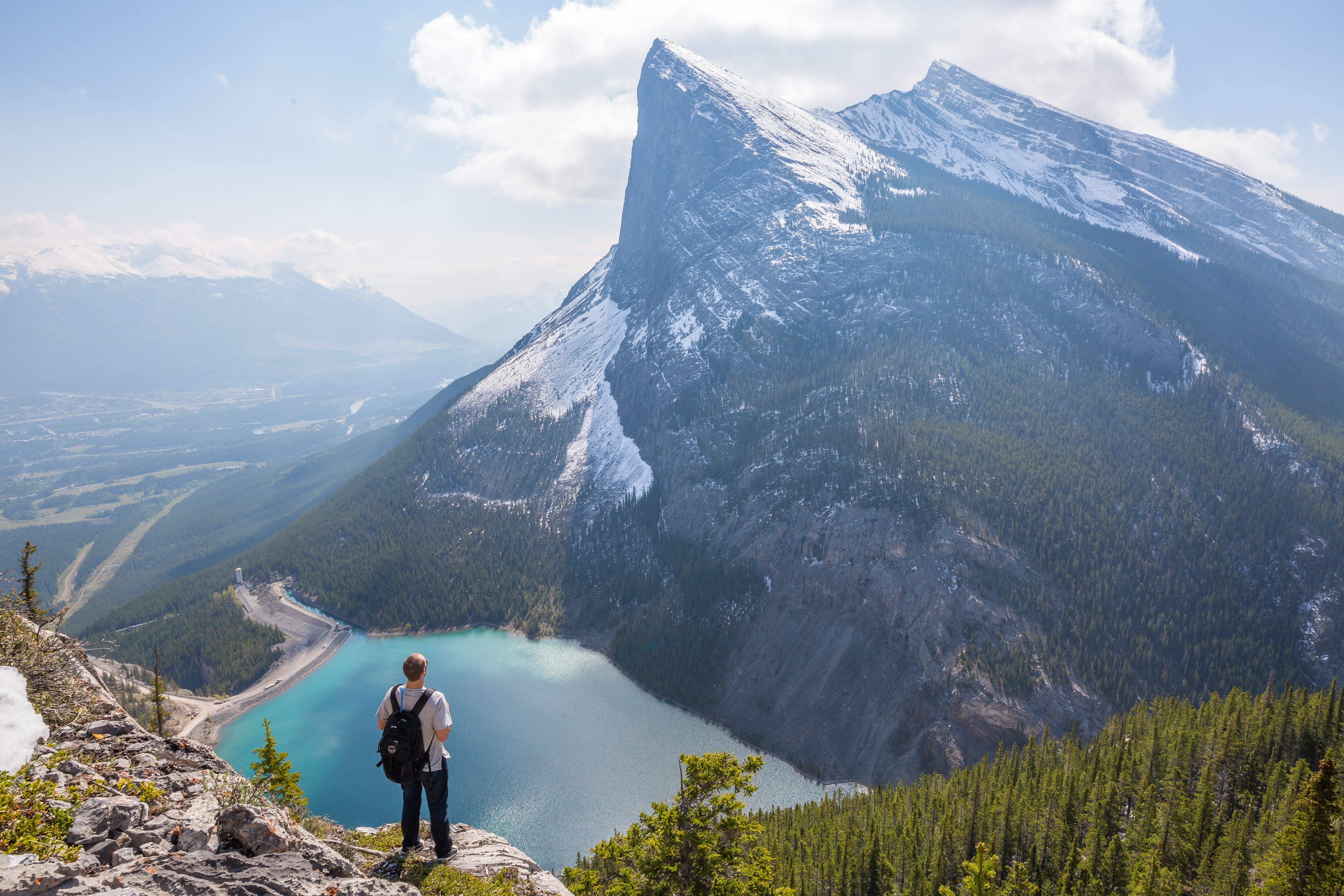 Man on a mountain overlooking a lake in the Canadian Rocky Mountains HD Wallpaper
