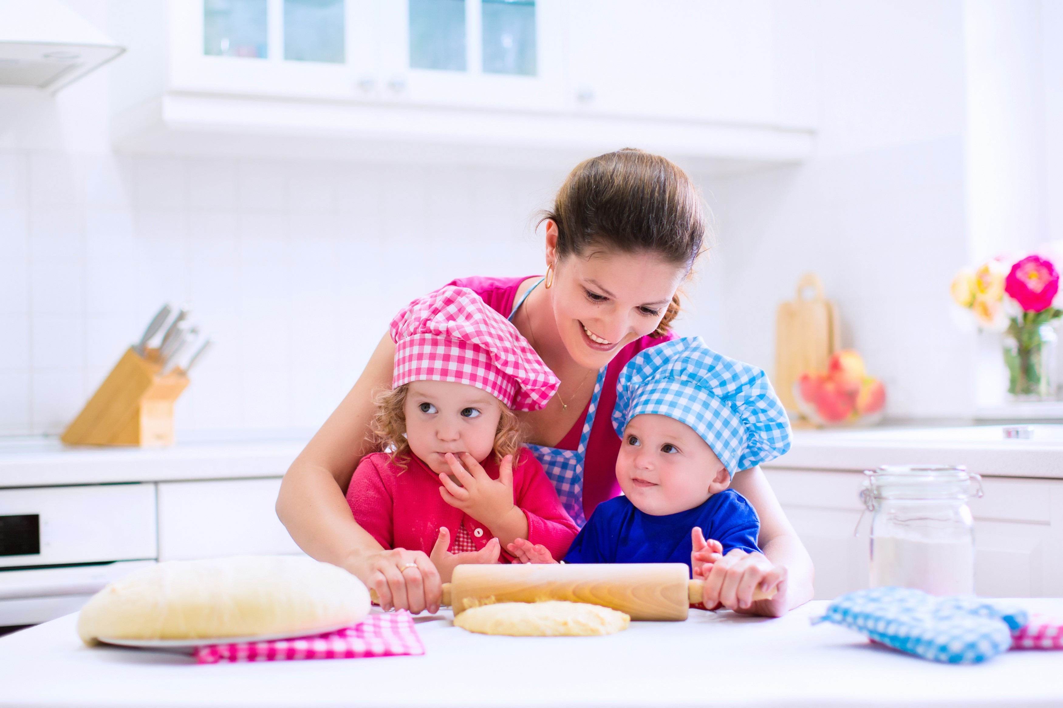 Mother and two children baking in a kitchen HD Wallpaper