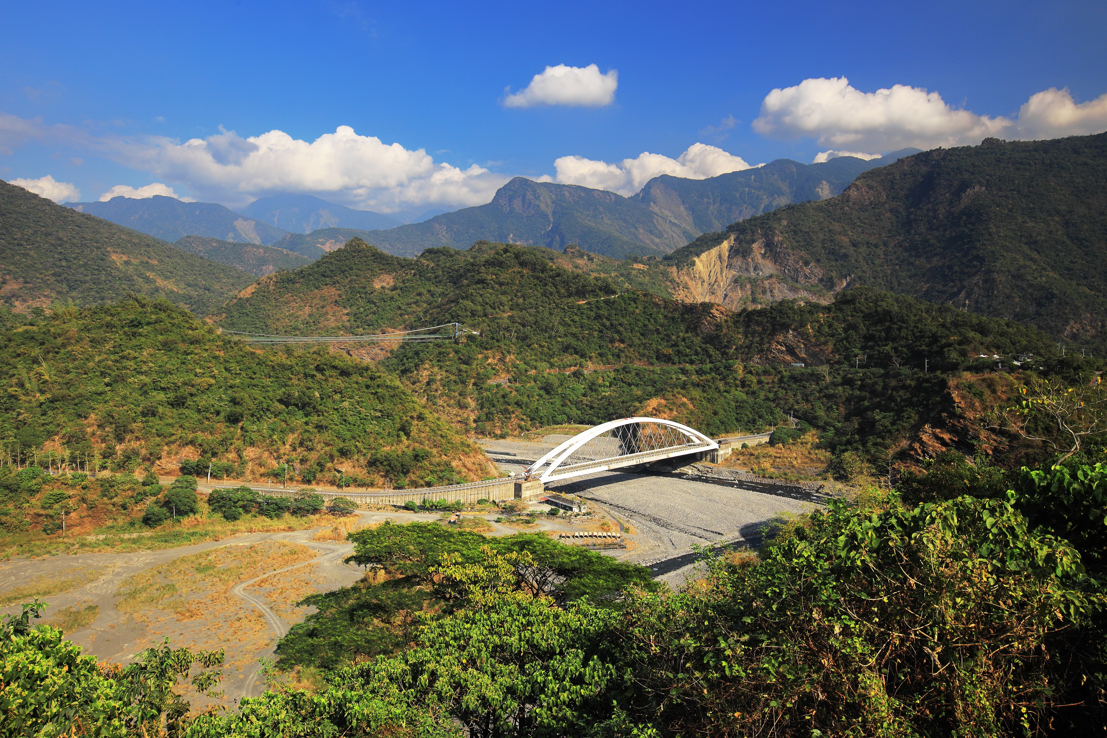 White arch bridge over a dry riverbed in Taiwan mountains HD Wallpaper