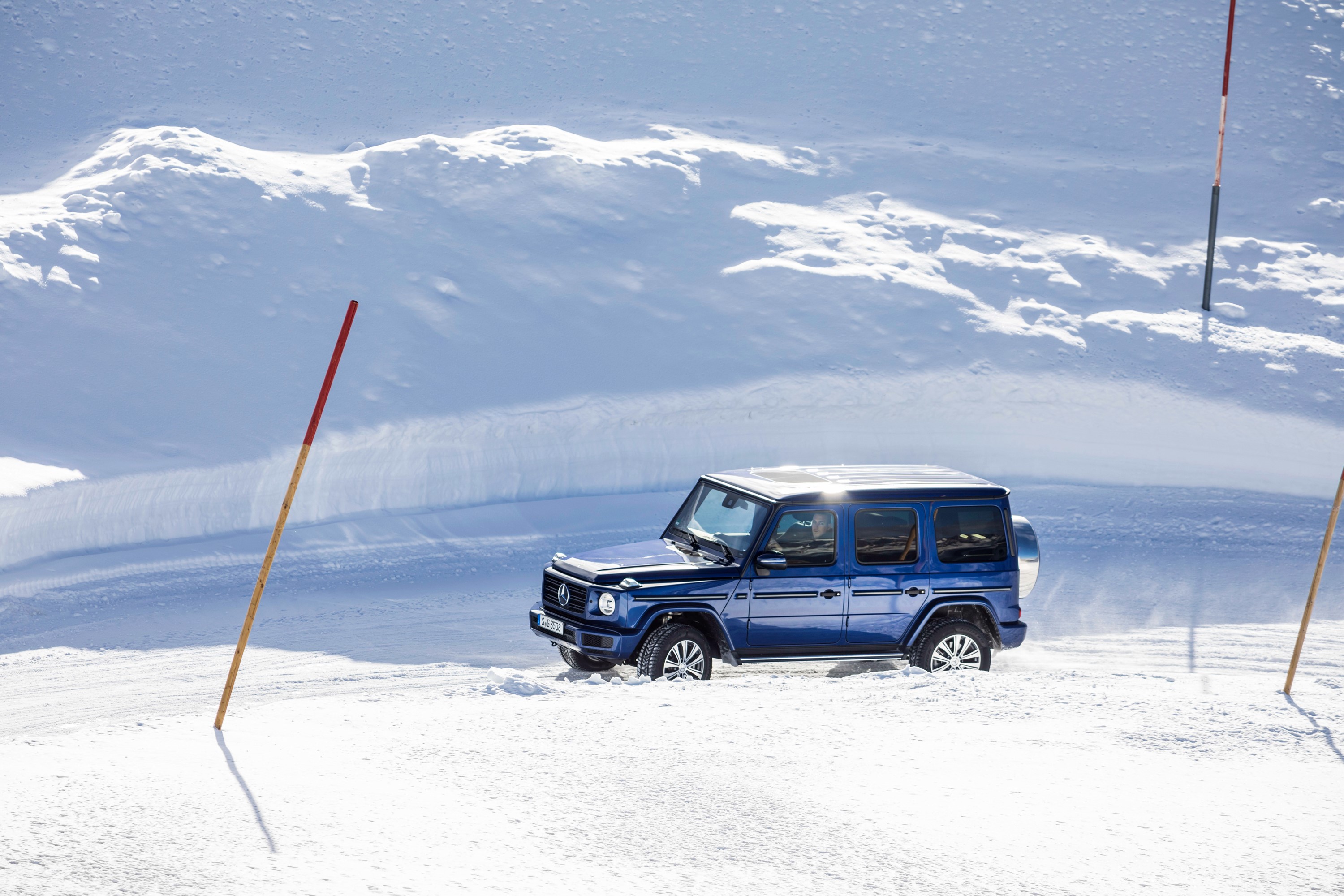 Blue Mercedes-Benz G-Class driving in snow HD Wallpaper