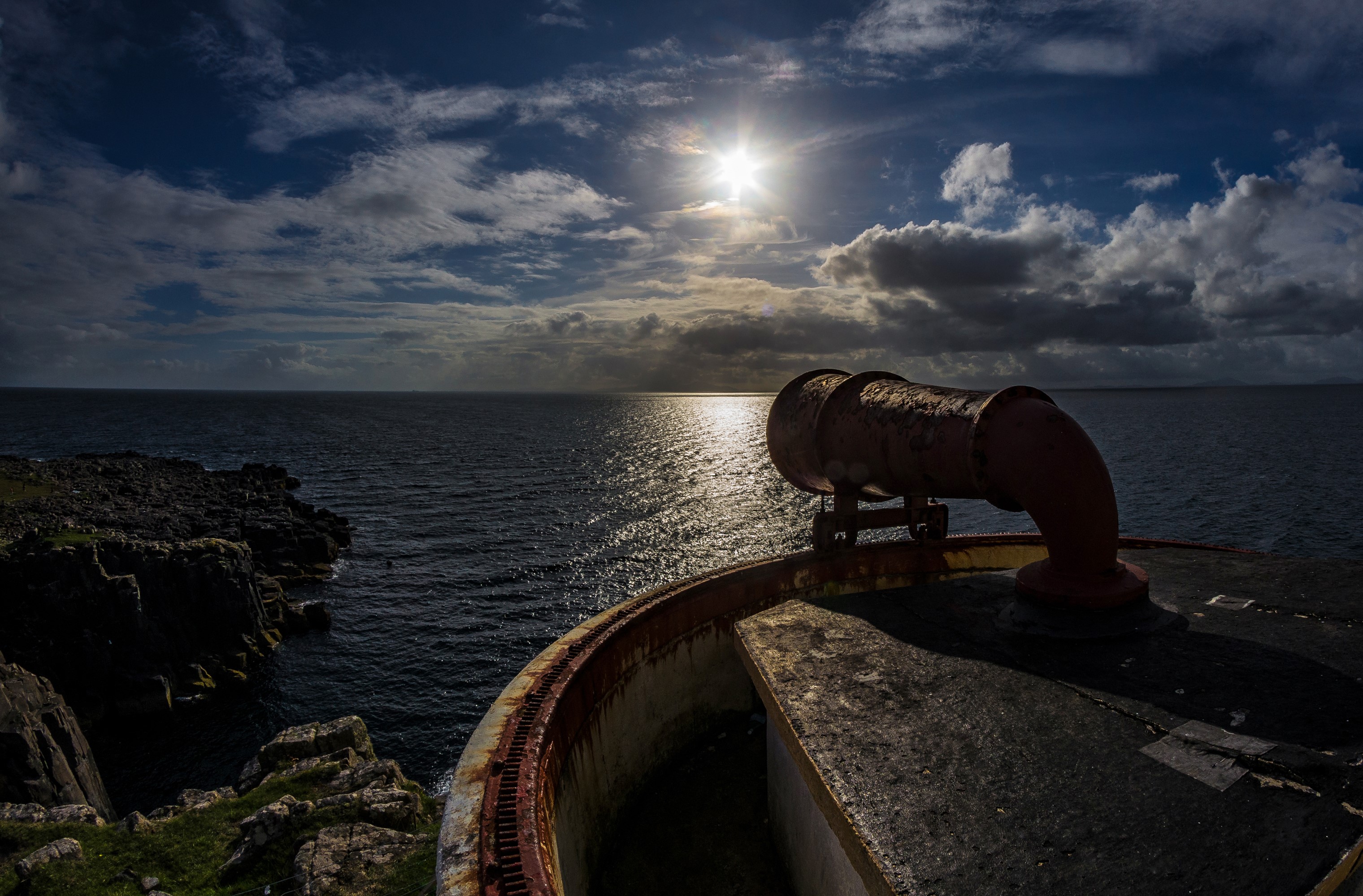 Rusty pipe on a cliff overlooking the sea at sunset HD Wallpaper