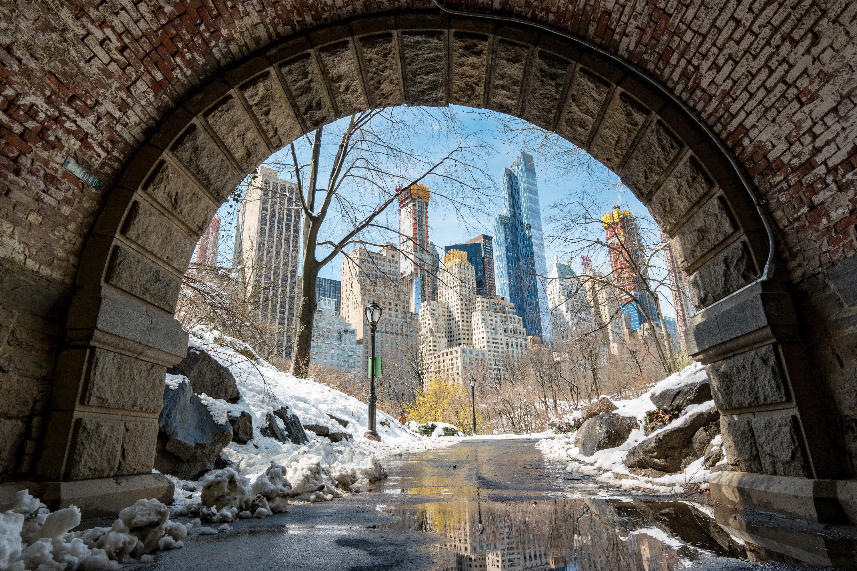 New York City skyline viewed through a stone archway in winter HD Wallpaper